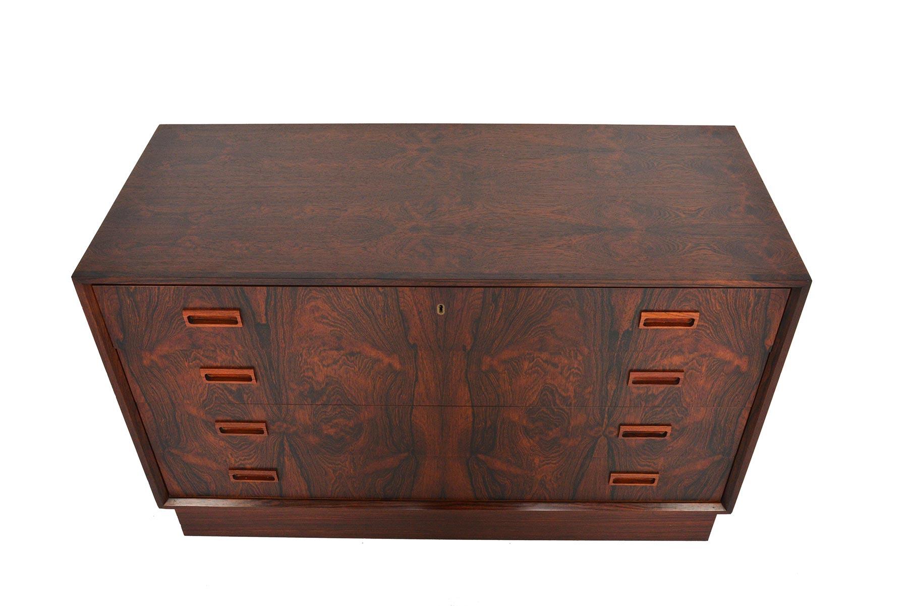The most striking quality of this low four-drawer Danish modern gentleman’s chest is the vivid and figurative grain of Brazilian rosewood. Housed in an inset mitered case, four drawers offer exceptional storage. The case stands on its original