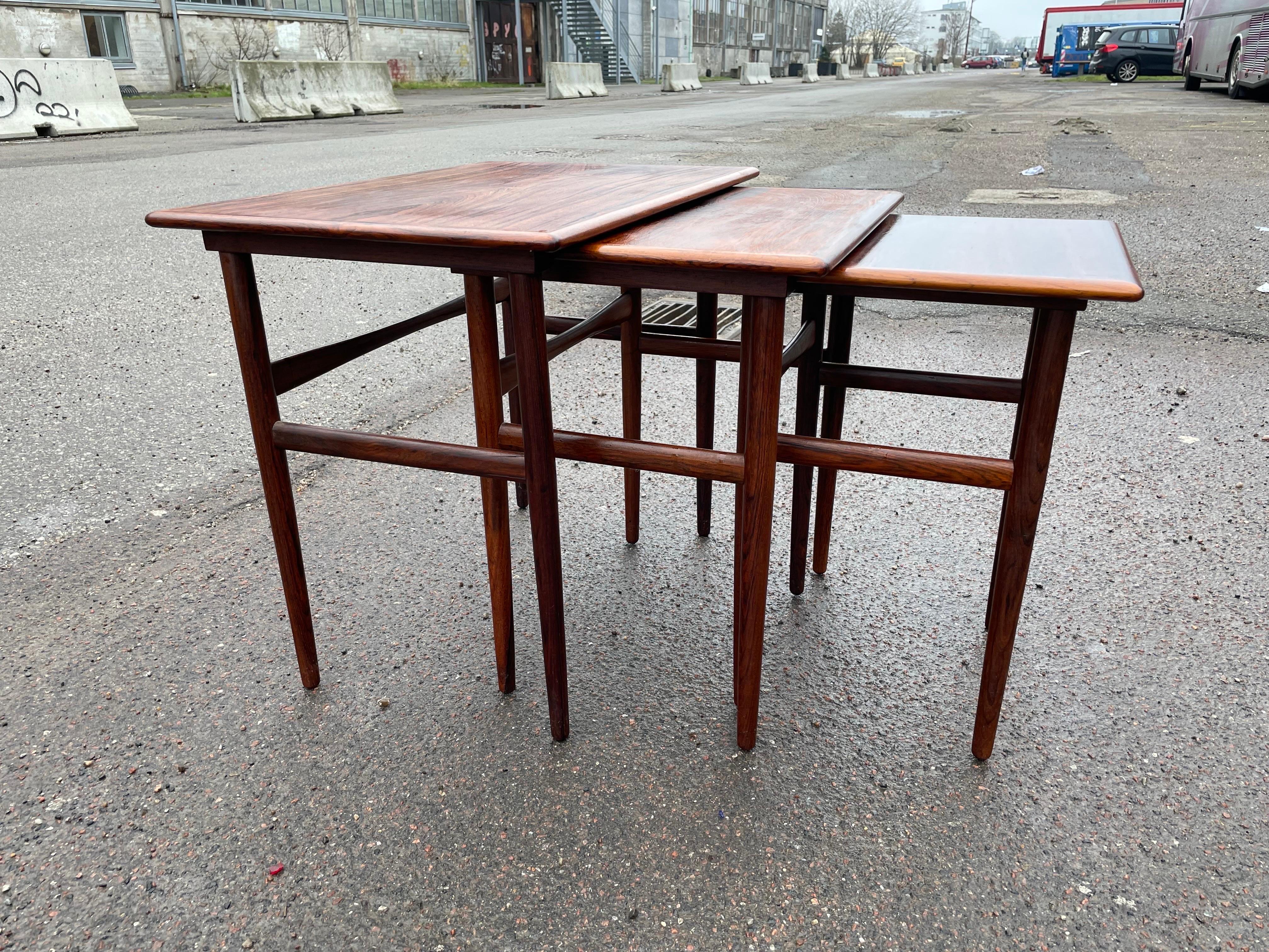 These Danish Mid-Century Modern nesting tables from the 1960s are the epitome of sleek, minimalistic design. The clean lines and functionality of the tables make them a perfect addition to any modern living space. The nesting feature allows for