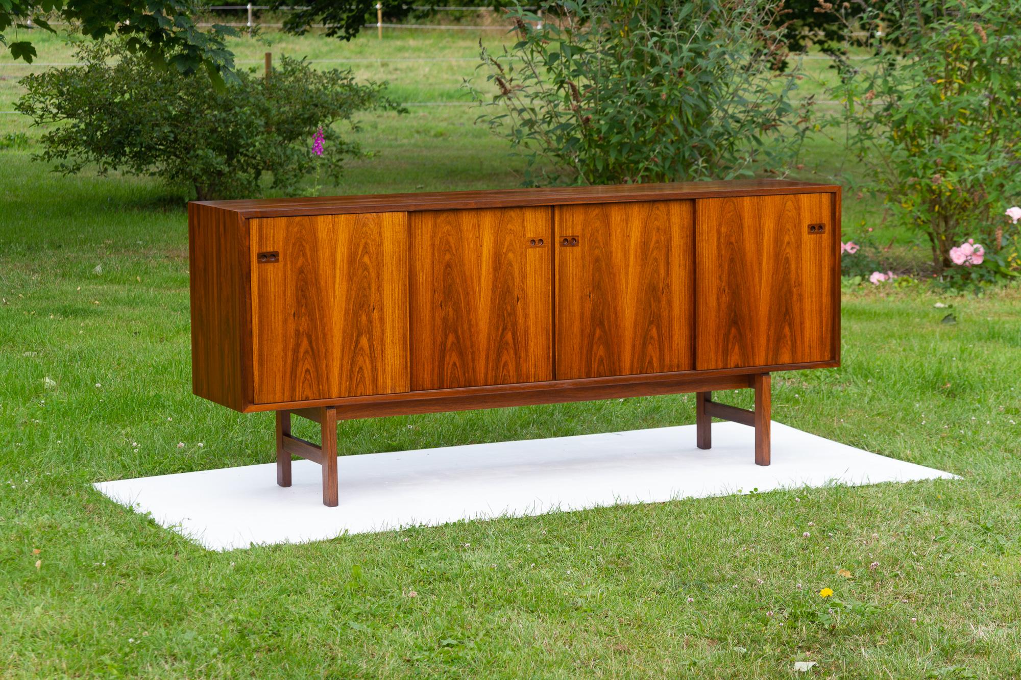 Buffet bas danois en palissandre, moderne du milieu du siècle, années 1960
Magnifique buffet bas moderne danois de style minimaliste attribué au designer danois Arne Vodder pour Sibast.
Façade avec quatre portes coulissantes et tirettes intégrées