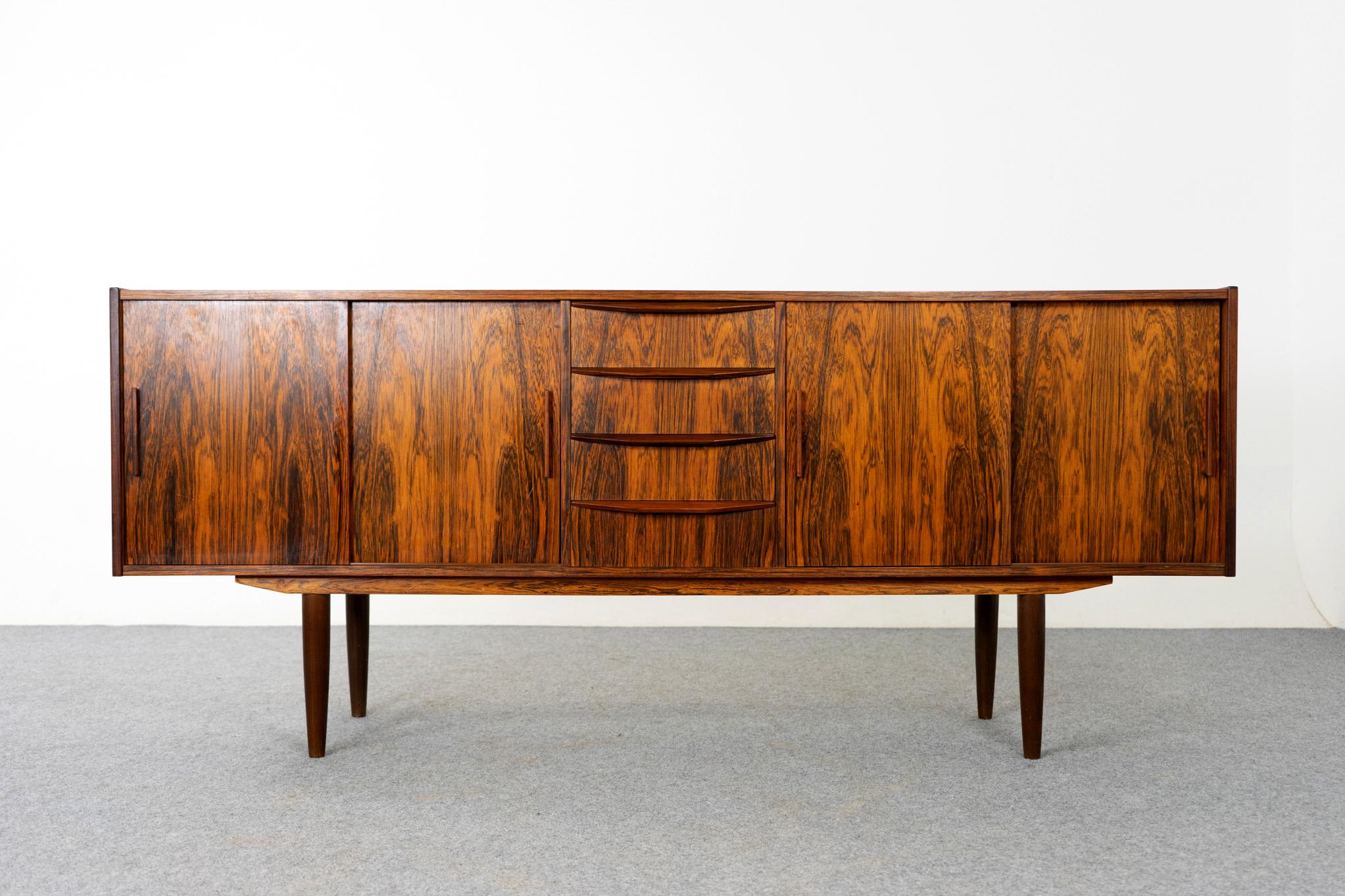 Rosewood Danish sideboard circa 1960's. Great proportions! Clean, simple lined design with exceptional book-matched veneer throughout. Sliding doors and exterior drawers offers ample storage for a variety of different uses. Main body of the cabinet
