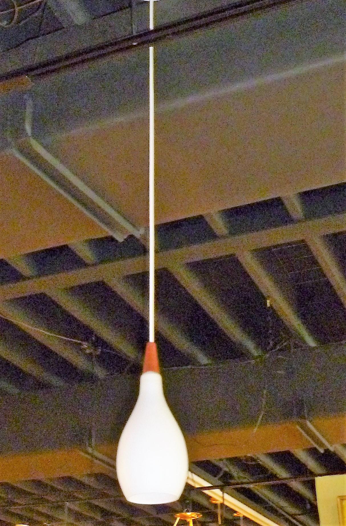1950s Danish Satin Glass and Teak Teardrop Pendant. A beautiful teardrop shaped blown satin glass globe with a teak top. Rewired with new cordage and new UL porcelain socket taking a standard base bulb and new ceiling canopy. 75 watts max, we