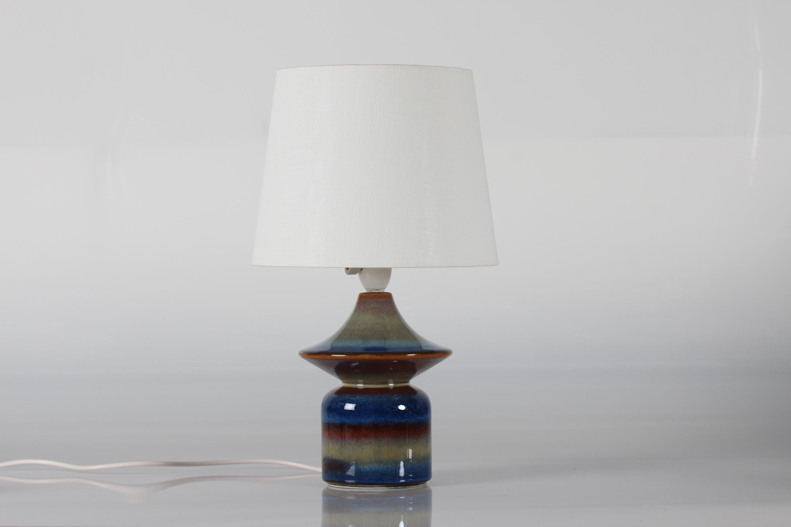Small stylish and sculptural Danish midcentury table lamp made of ceramic with glaze in blue and green colors.
The lamp is made at the acknowledged pottery Søholm on Bornholm, circa 1960s.

The lamp remains in good vintage condition and comes