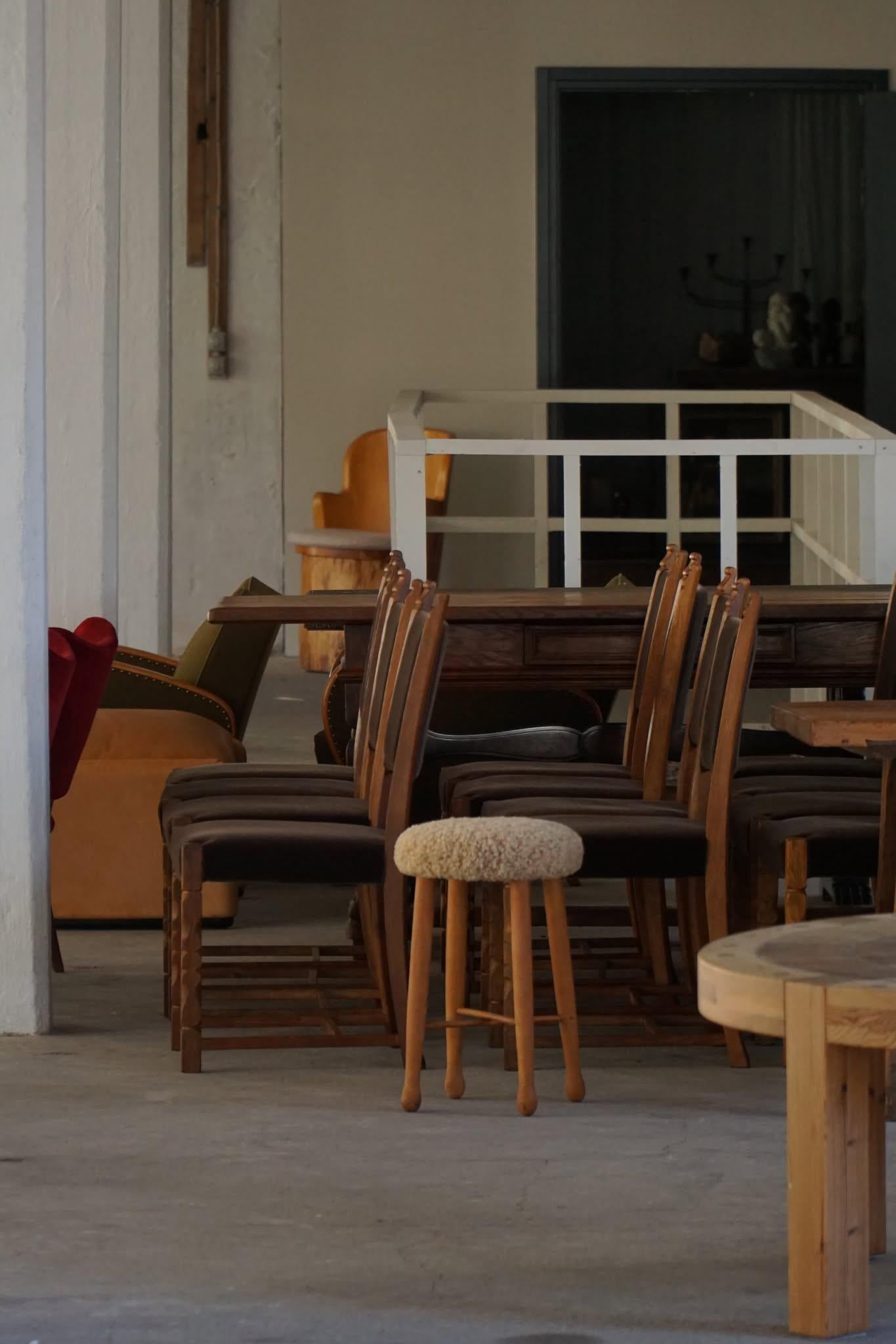 Un encantador taburete danés de la modernidad de mediados de siglo, con un cómodo asiento tapizado en suave lana de cordero tono miel. Las cuatro patas de madera maciza están elegantemente ahusadas, ofreciendo a la vez estabilidad y un perfil