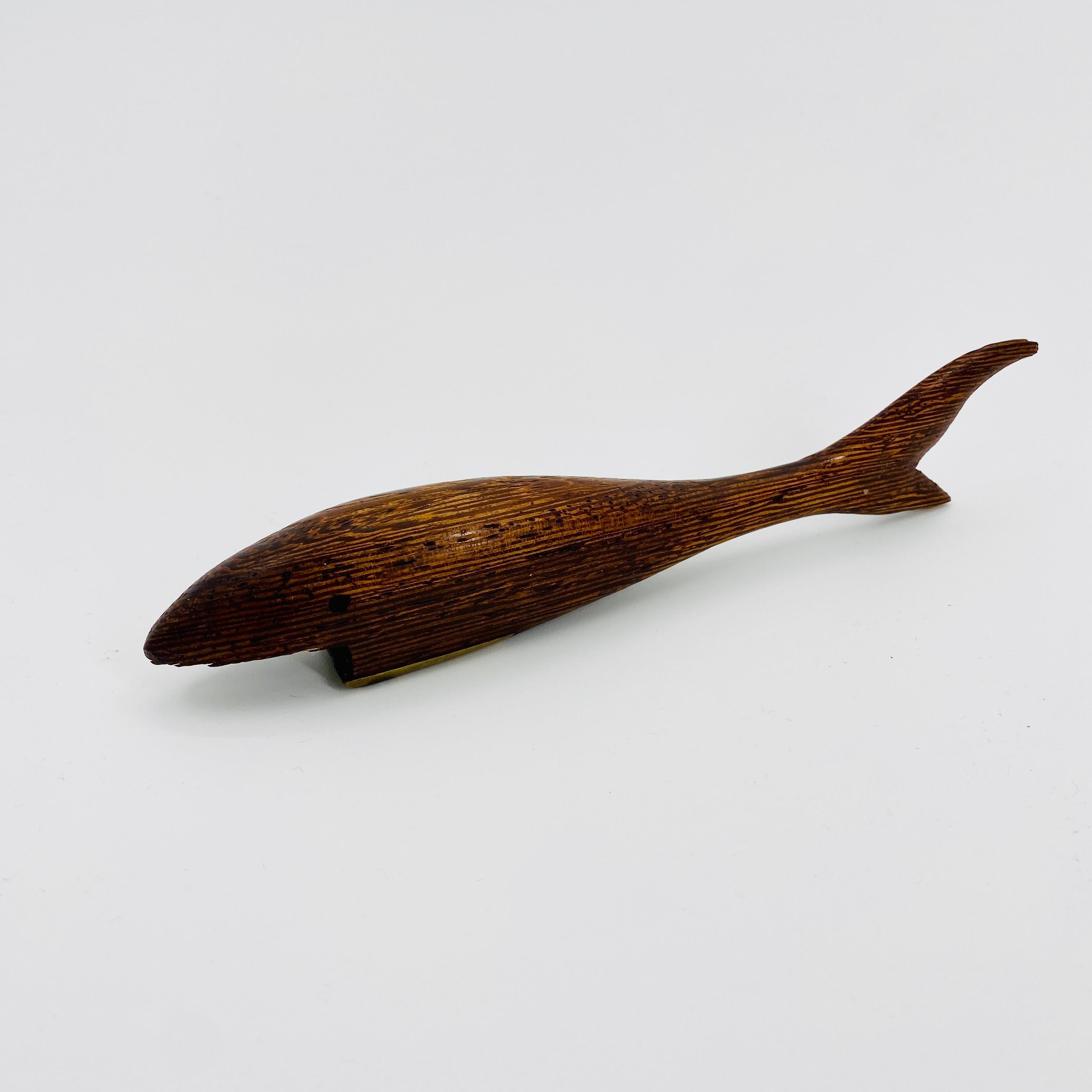 Scandinavian modern oak and brass fish shaped bottle opener

Danish Arts and Crafts bottle opener formed as a shark made in brass and oak wood. Then bottle opener feels very smooth and rests well in your hand. It is handcrafted and the oak has an