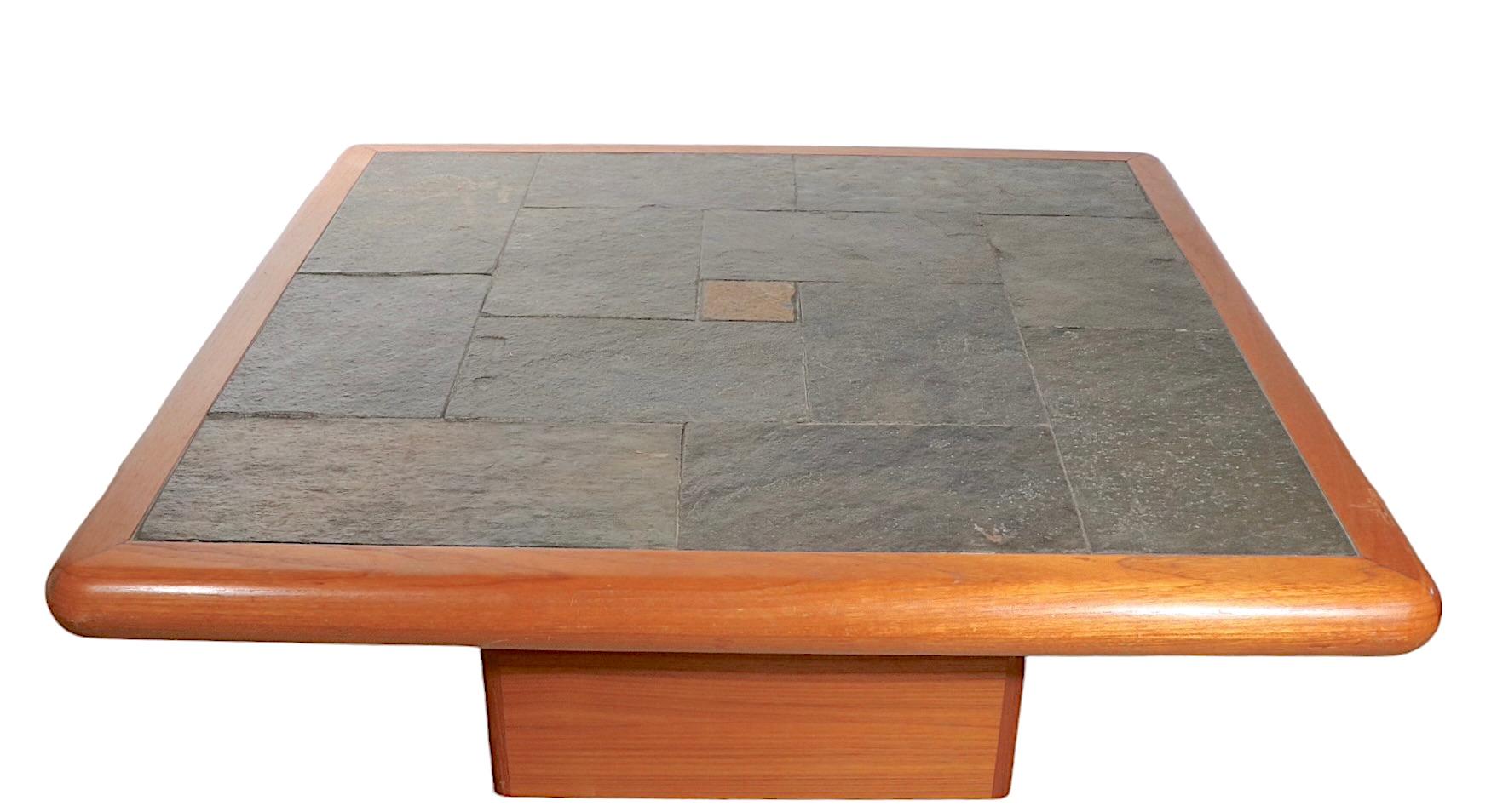 Chic vintage Sallingboe coffee table having a geometric inlay slate top, mounted in a thick teak frame, which rests on a center rectangular teak pedestal base. The table is in very good, vintage condition, it shows a couple of cosmetic blemishes,