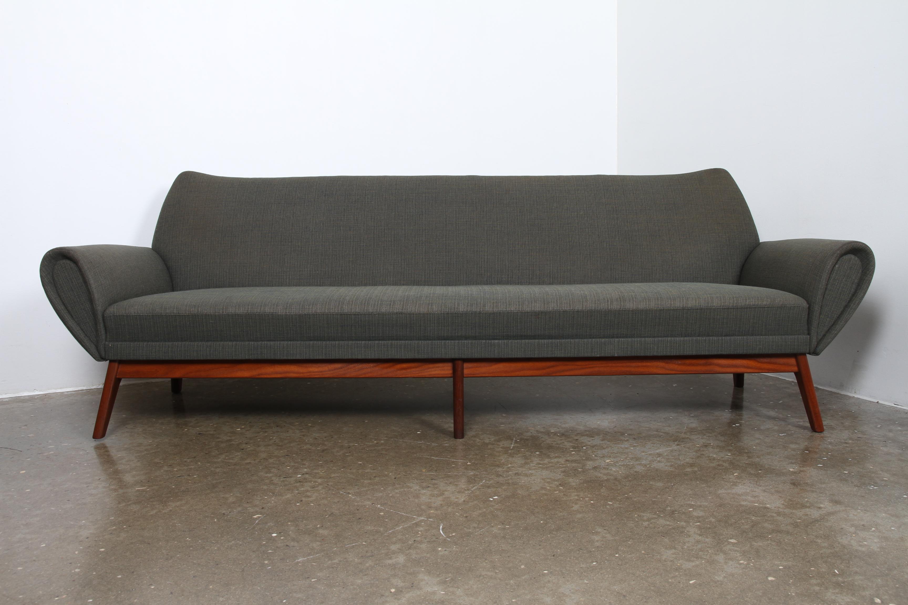 Probably the most beautiful couch ever made in Denmark. Immensely elegant vintage design. This a rare four-seater and it is the original green upholstery. Elegant curved armrests. Solid teak frame with six legs completes this rare work of art.