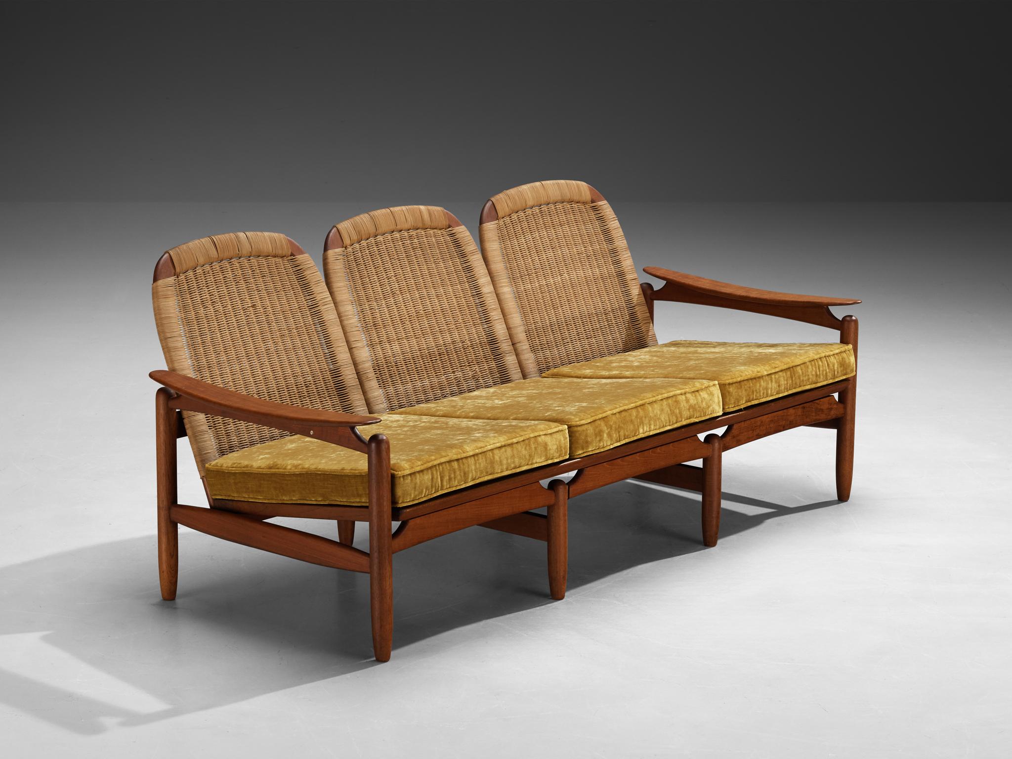 Divano a tre posti, teak, canna, metallo, Danimarca, anni '60

Questo divano a tre posti di origine danese sfoggia un design moderno di metà secolo e una squisita lavorazione artigianale. La struttura scolpita, realizzata in ricco legno di teak,