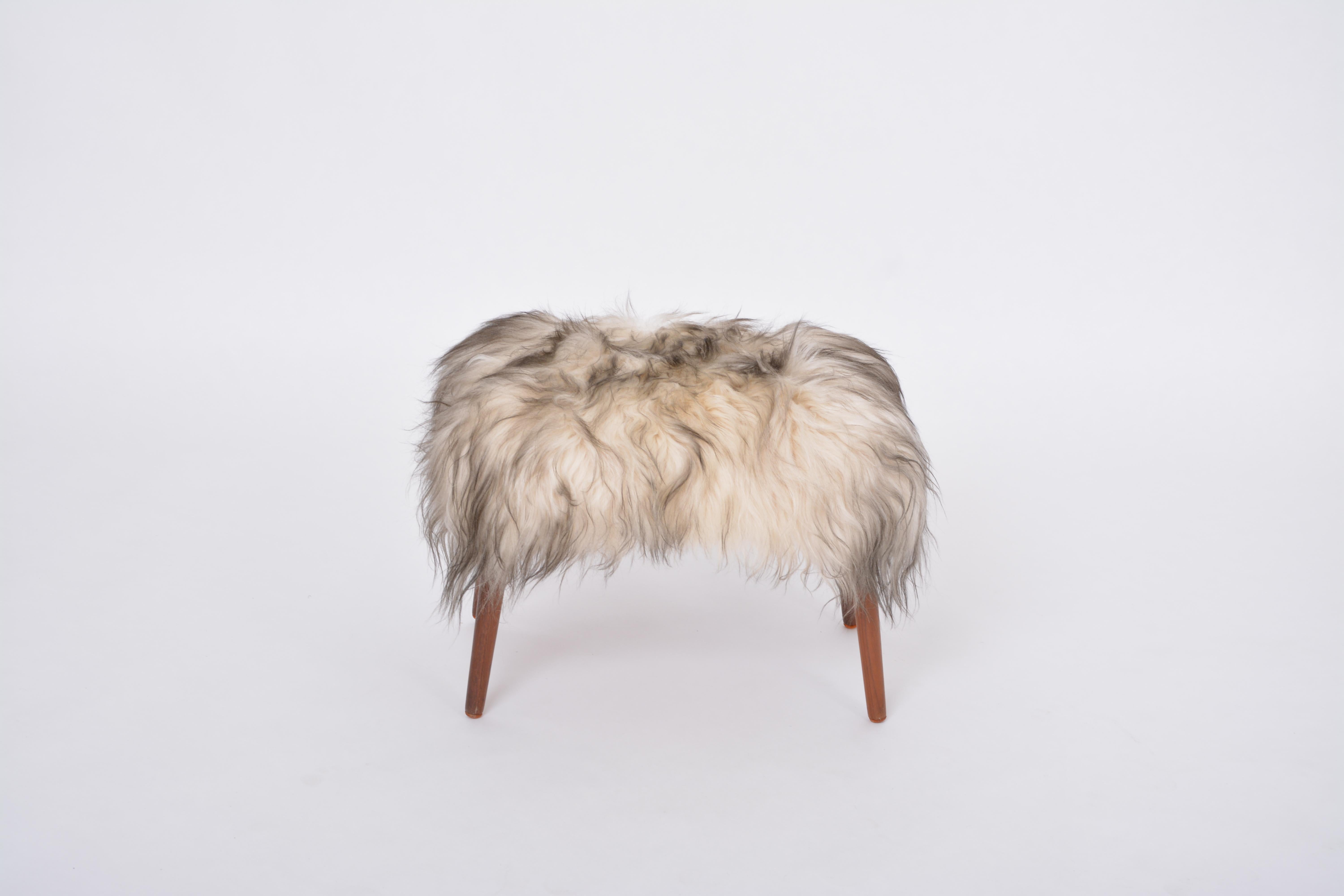 Sgabello danese della metà del secolo scorso rivestito in pelle di pecora bianca e nera
Questo pouf/sgabello è stato progettato e prodotto negli anni '50 in Danimarca. È realizzato in  Il legno è stato rivestito con una pelle di pecora bianca e nera