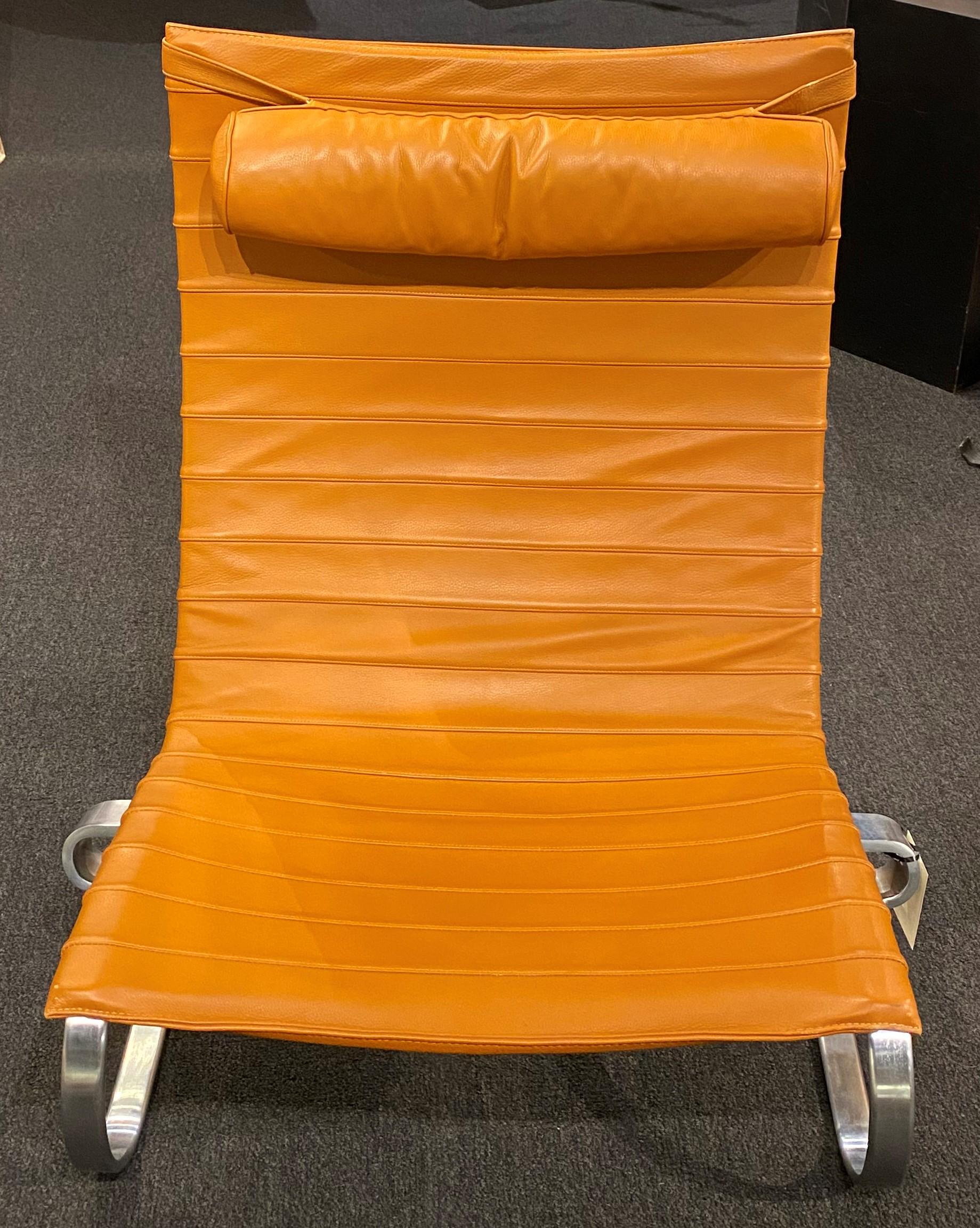 Der von Poul Kjærholm für Fritz Hansen A/S in Dänemark entworfene PK20 ist ein bequemer und eleganter Lounge- oder Sessel mit orangefarbenem Ledersitz und Kopfstütze in einem flexiblen, matt verchromten Federstahlgestell. Signiert und datiert 2000
