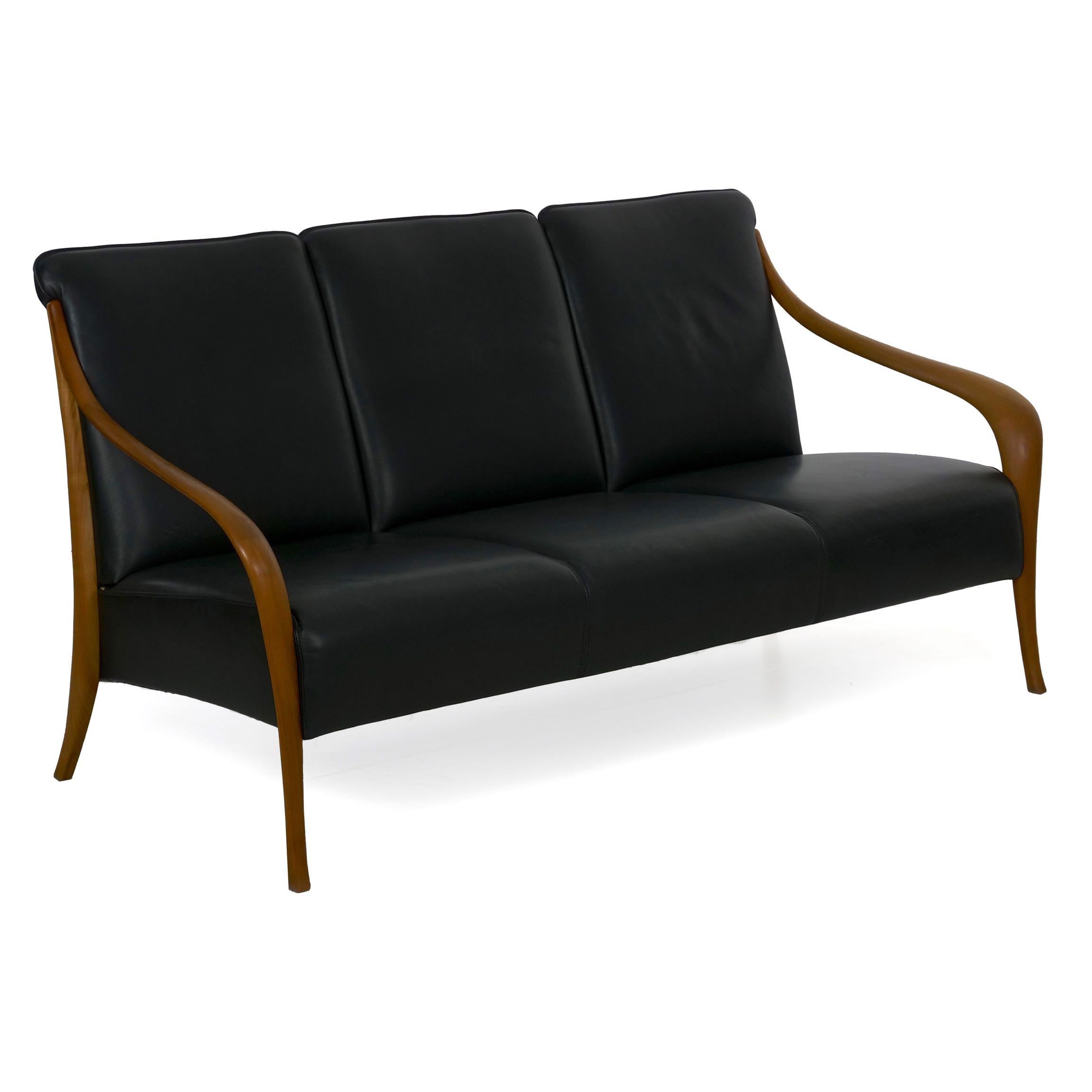 A very attractive Scandinavian Modern style sofa, the sculpted teak arms are an unusually powerful design element. Bold and robust, they have a very natural and relentless curvature that terminates in an ever so slightly outward splayed leg. These