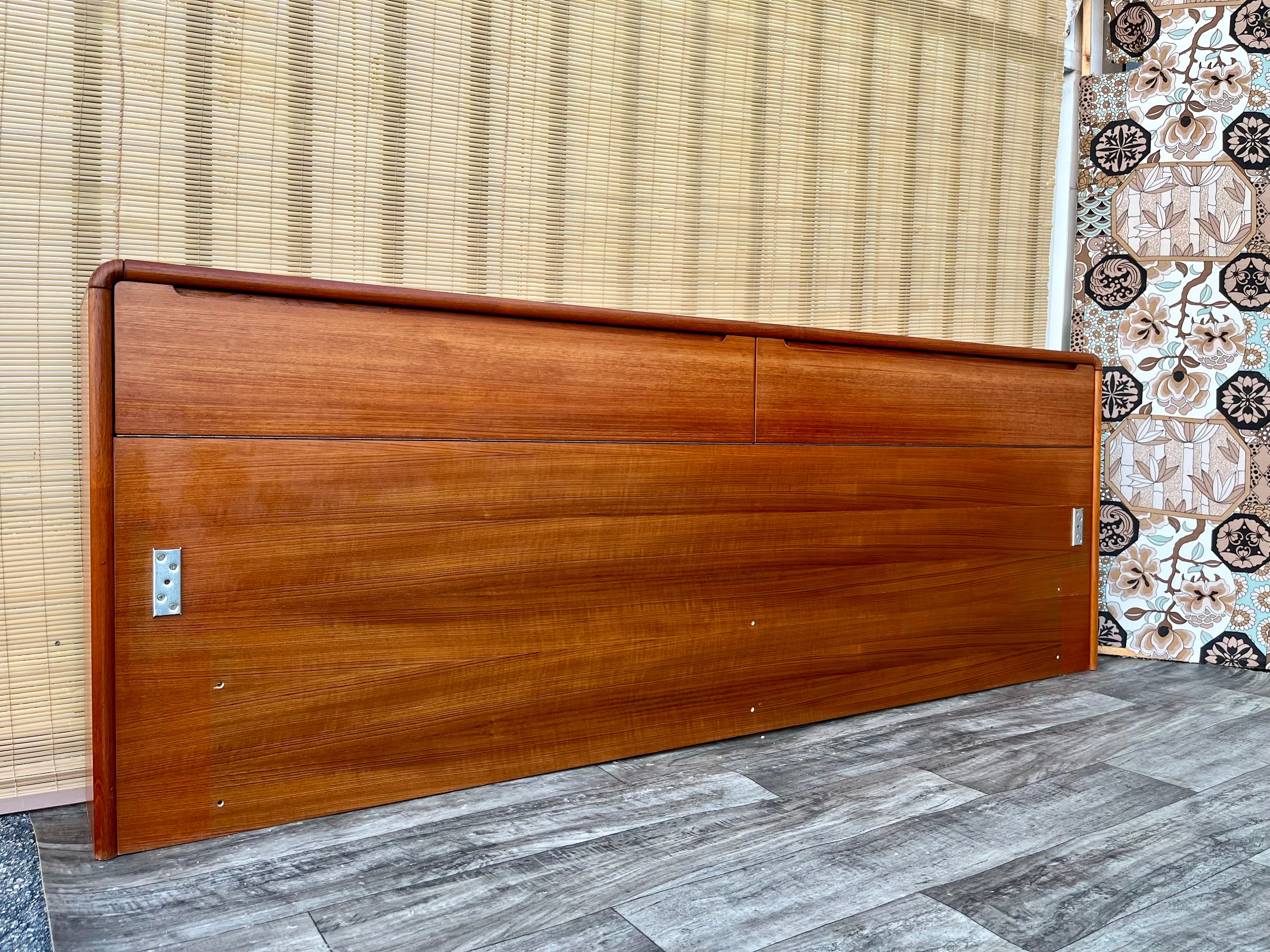Vintage Danish Mid Century Modern Style Teak King Headboard With Storage by Sun Cabinet. Circa 1980s. 
 Features a sleek Scandinavian Modern Design with two concealed storage compartments with stylish recessed pulls , gorgeous curved-edge design