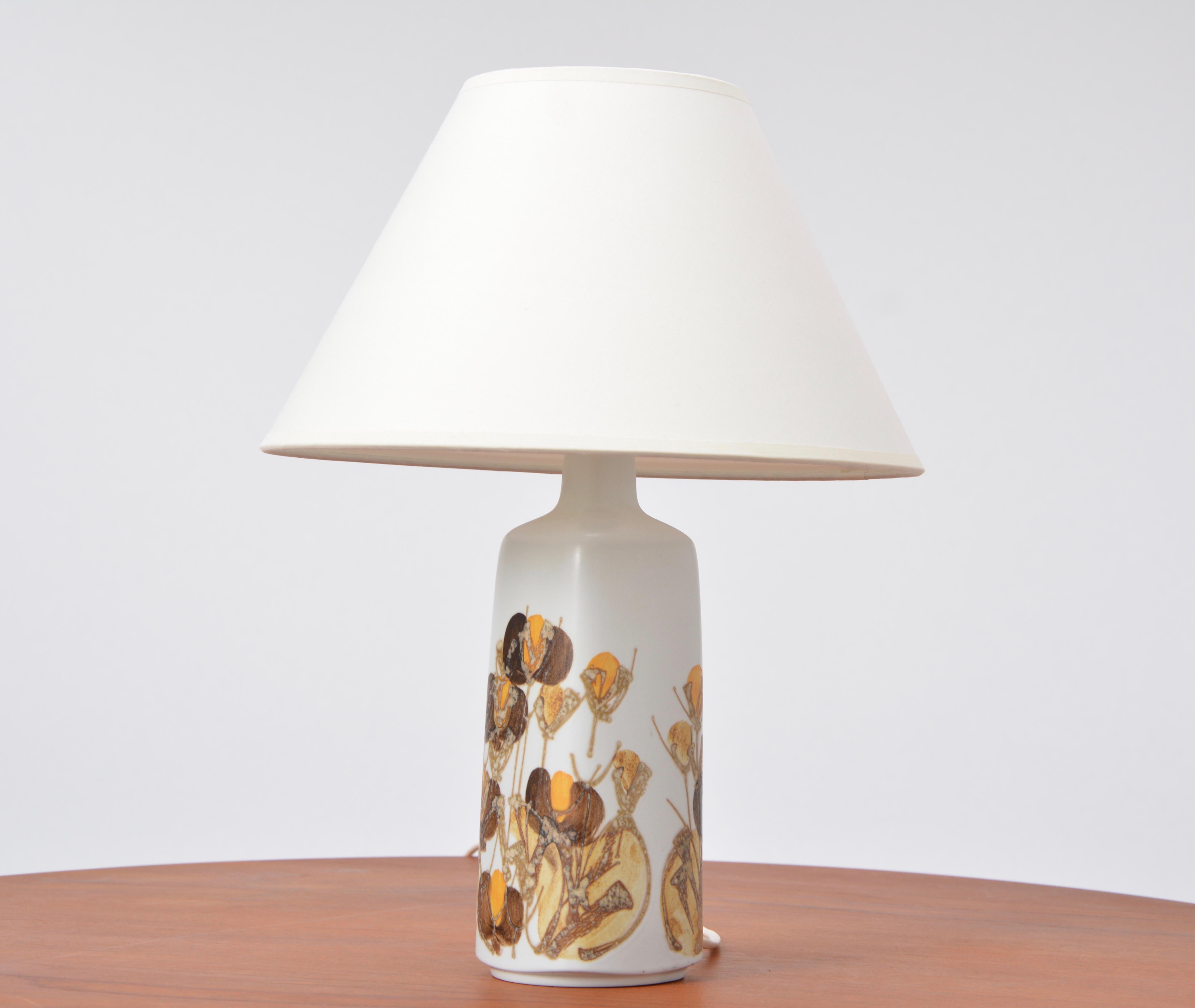 This table lamp was produced by Royal Copenhagen in the 1960s. The beautiful flora pattern was designed by Danish artis Ellen Malmer. The lamp has a new shade.