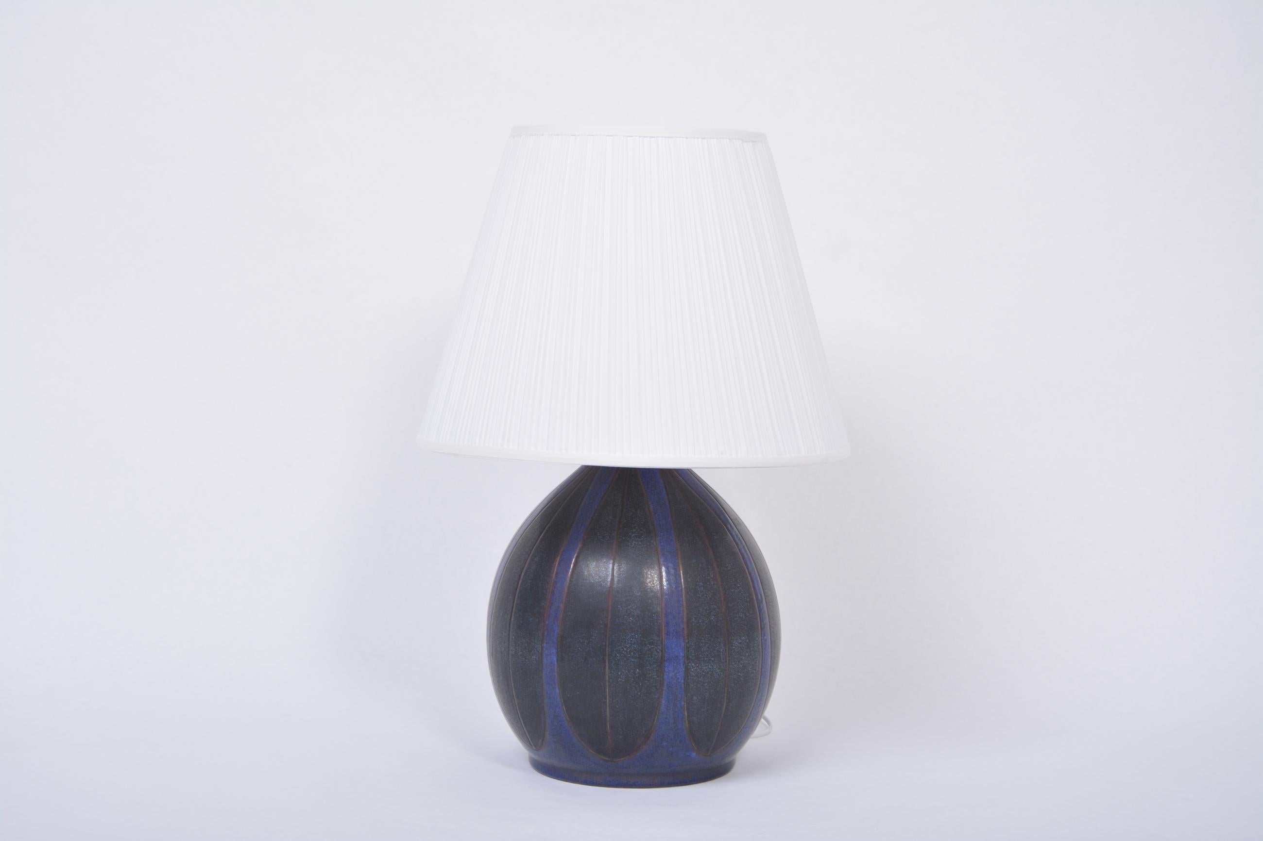 Danish Mid-Century Modern table lamp by Michael Andersen
Gorgeous and very rare ceramic table lamp produced by Michael Andersen & Sons in Bornholm, Denmark in the 1970s. Circular base with graphic pattern colored in dark blue and black. The lamp is