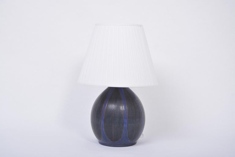 Danish Mid-Century Modern table lamp by Michael Andersen
Gorgeous and very rare ceramic table lamp produced by Michael Andersen & Sons in Bornholm, Denmark in the 1970s. Circular base with graphic pattern colored in dark blue and black. The lamp is