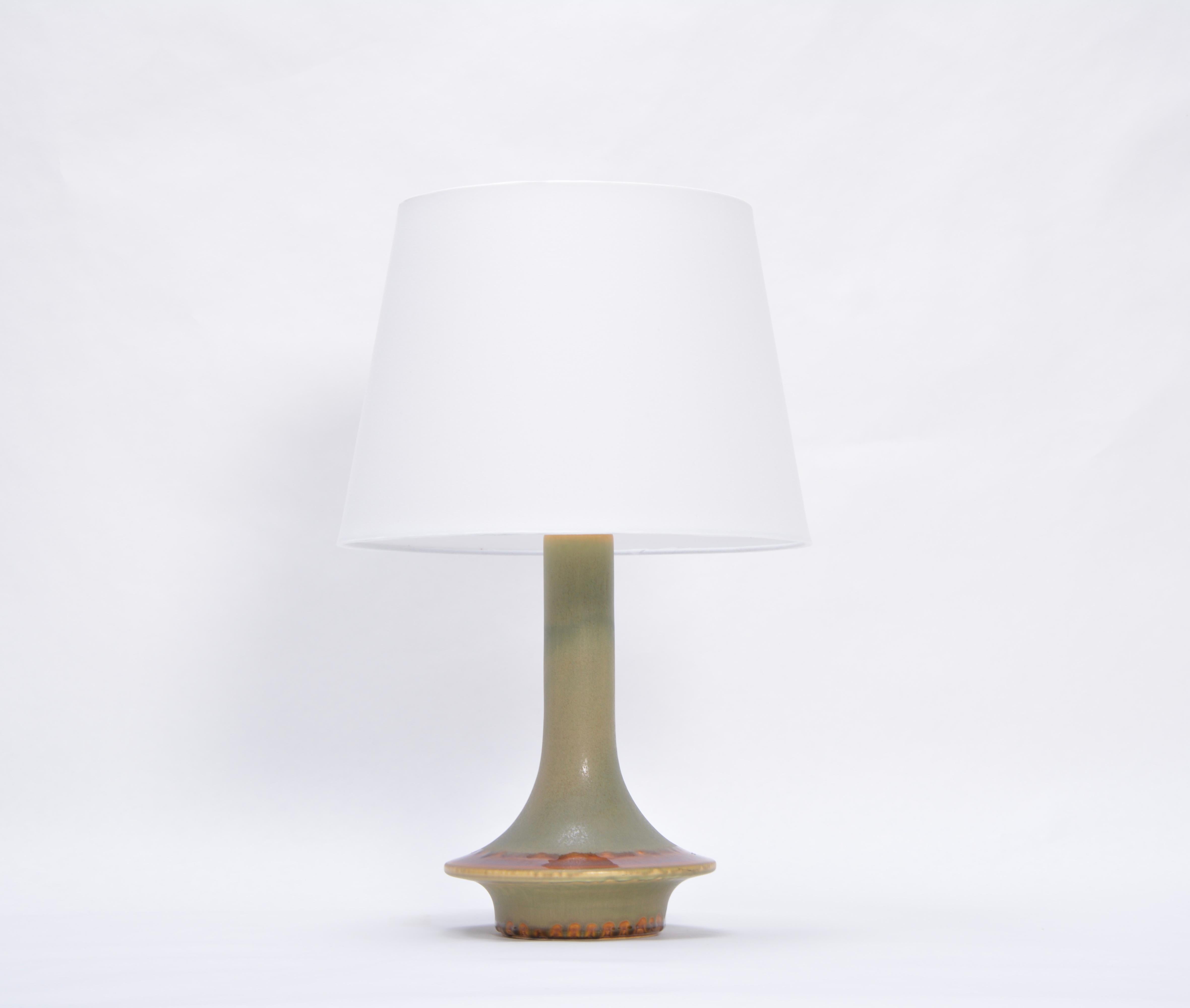 Danish Mid-Century Modern table lamp model 1068 by Soholm.

Stoneware table lamp with circular shaped base and long neck produced in Denmark by Soholm. Beautiful ceramic glazing in tones of brown and orange to the edge of the circular base. The