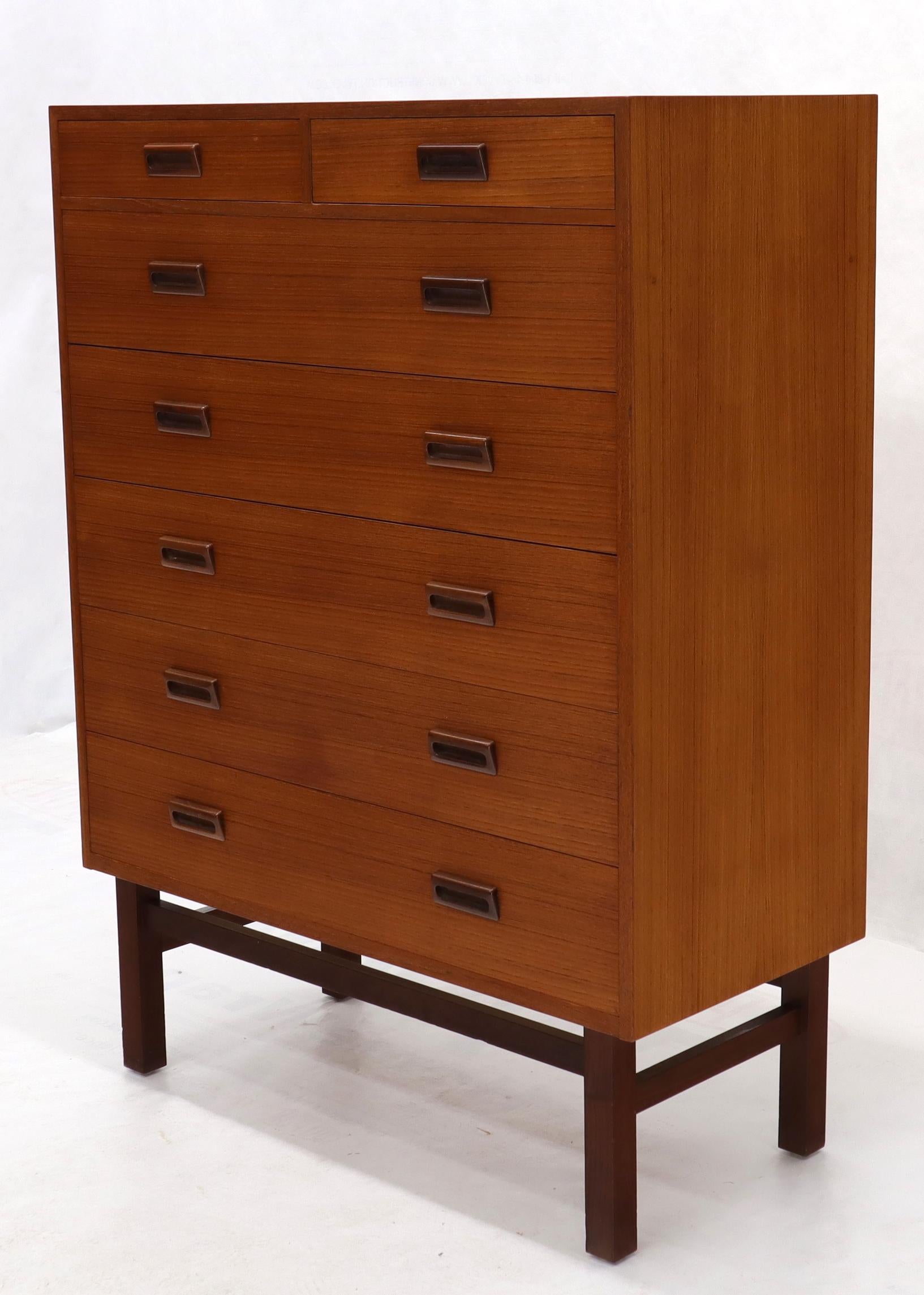 Danish modern tall teak dresser high chest of seven drawers cabinet. Excellent original condition standing on a nice solid teak square beam architectural stretchers base.