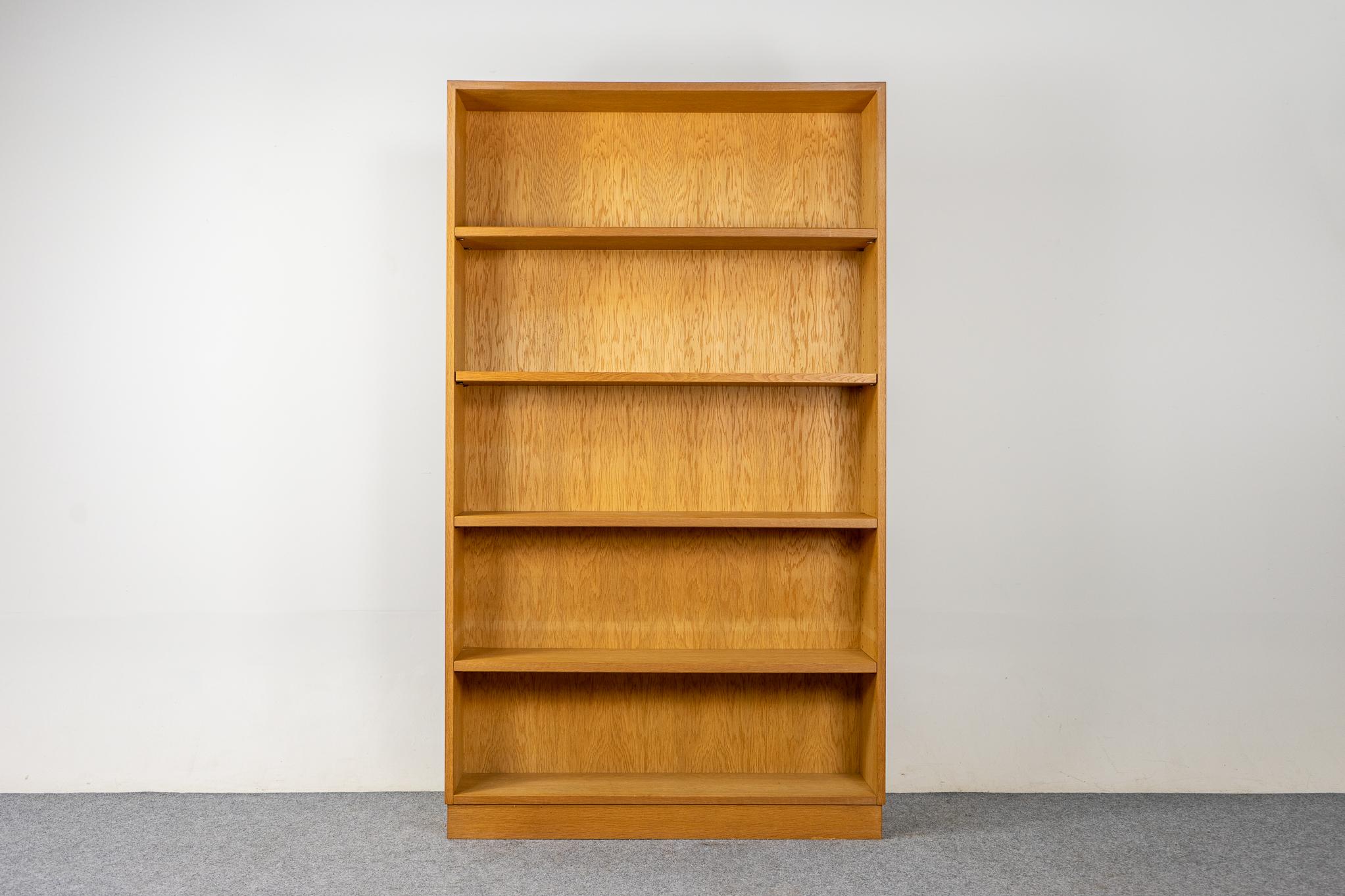 Danish Modern oak bookcase, circa 1960's. This open bookcase offers removable and adjustable shelving, removable legs and the compact design makes it the perfect condo sized storage solution. This tall open bookcase offers removable and adjustable