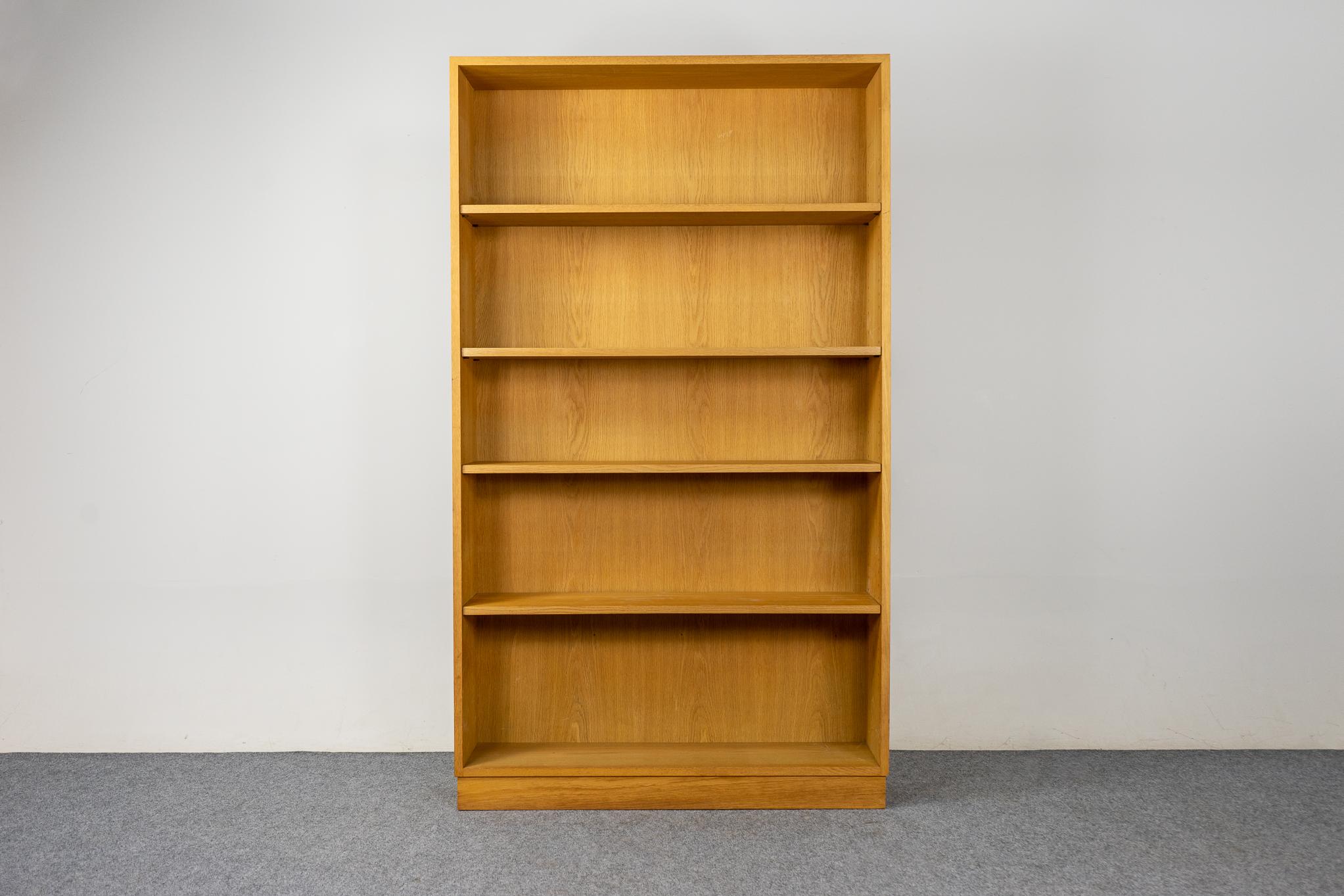 Danish Modern oak bookcase, circa 1960's. This open bookcase offers removable and adjustable shelving, removable legs and the compact design makes it the perfect condo sized storage solution. This tall open bookcase offers removable and adjustable