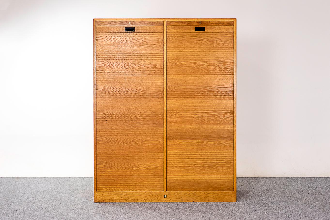 Oak Danish file cabinet, circa 1960's. Double bank tambour door file cabinet with adjustable shelving and pullout adjustable hanging file storage system.

Unrestored item with option to purchase in restored condition for an additional $400 USD.