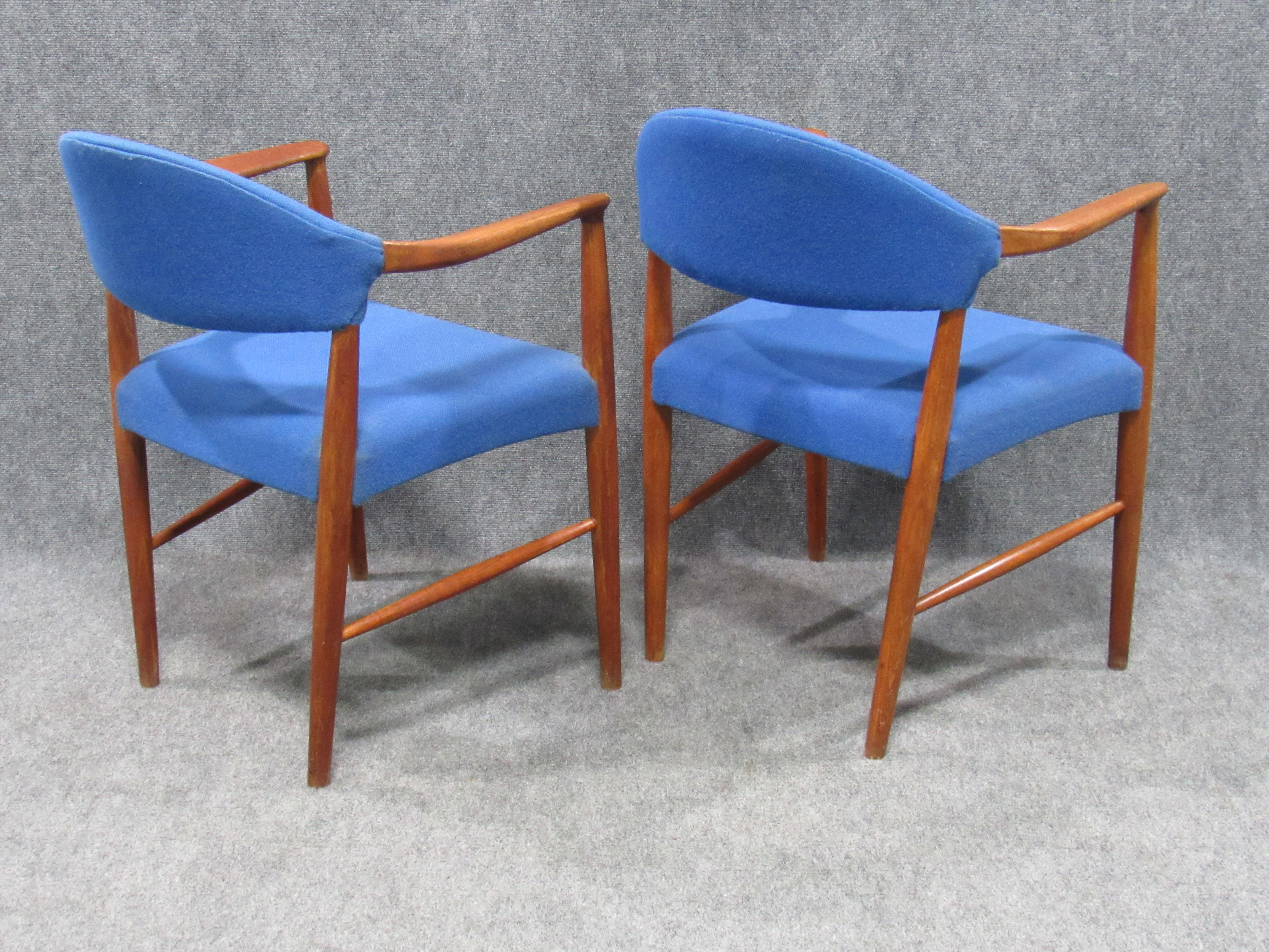 Achetée au Danemark, cette paire de fauteuils de salon danois en teck et laine bleue est attribuée à l'un des plus grands designers de chaises du milieu du siècle - Hans Wegner. Les courbes douces du dossier et la verticalité du cadre sont des