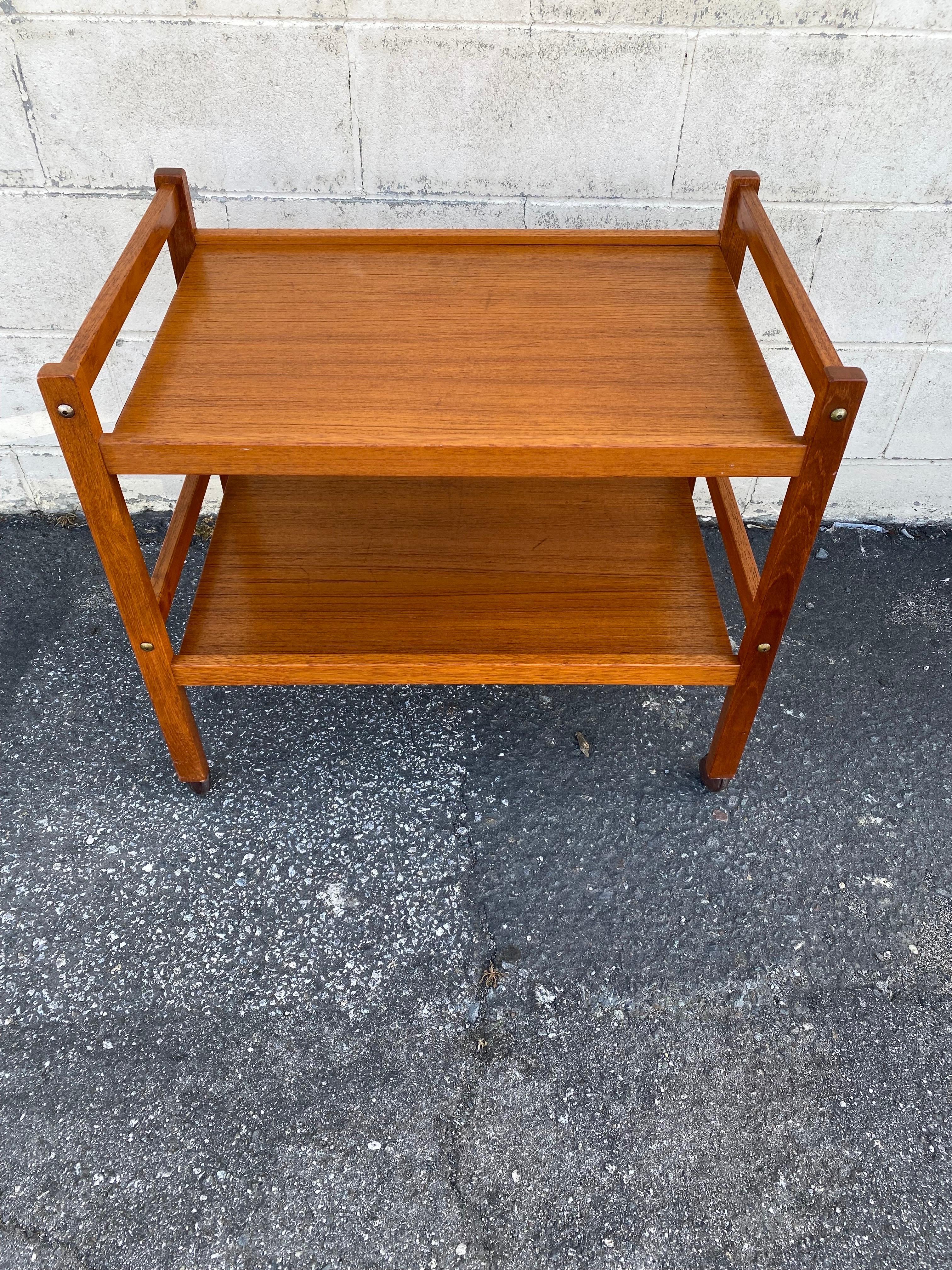 For sale we have a beautiful teak bar cart or tea cart made in Denmark by Brdr. Furbo. 

This 2 tiered, Danish Mid-Century Modern Bar cart is in excellent structural shape and very good cosmetic shape. This teak bar cart comes with age appropriate