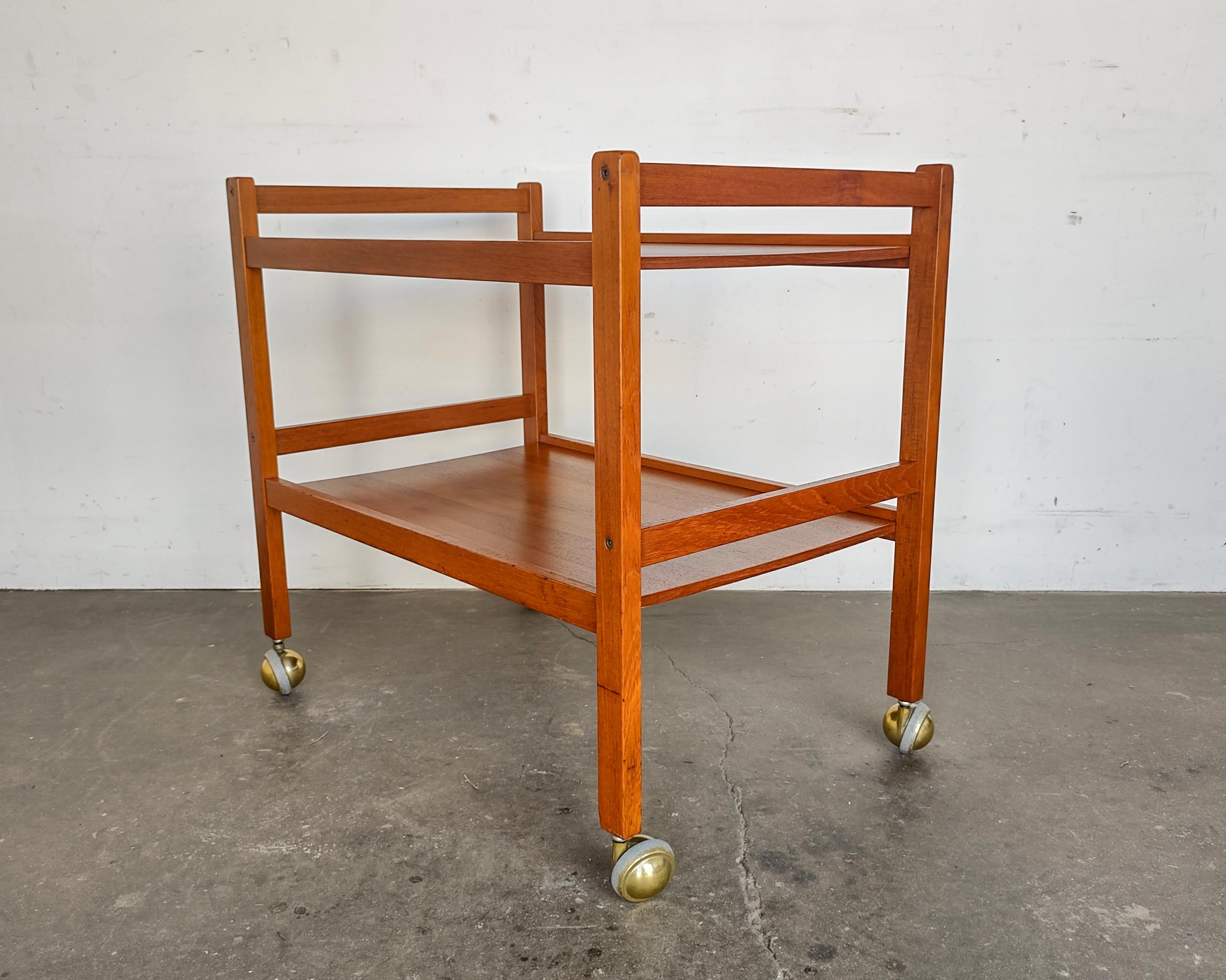Danish Mid-Century Modern teak wood bar cart by Brbr. Furbo. Features contrasting brass Shepard casters. Overall great vintage condition, a couple scratches, wear consistent with age.

28