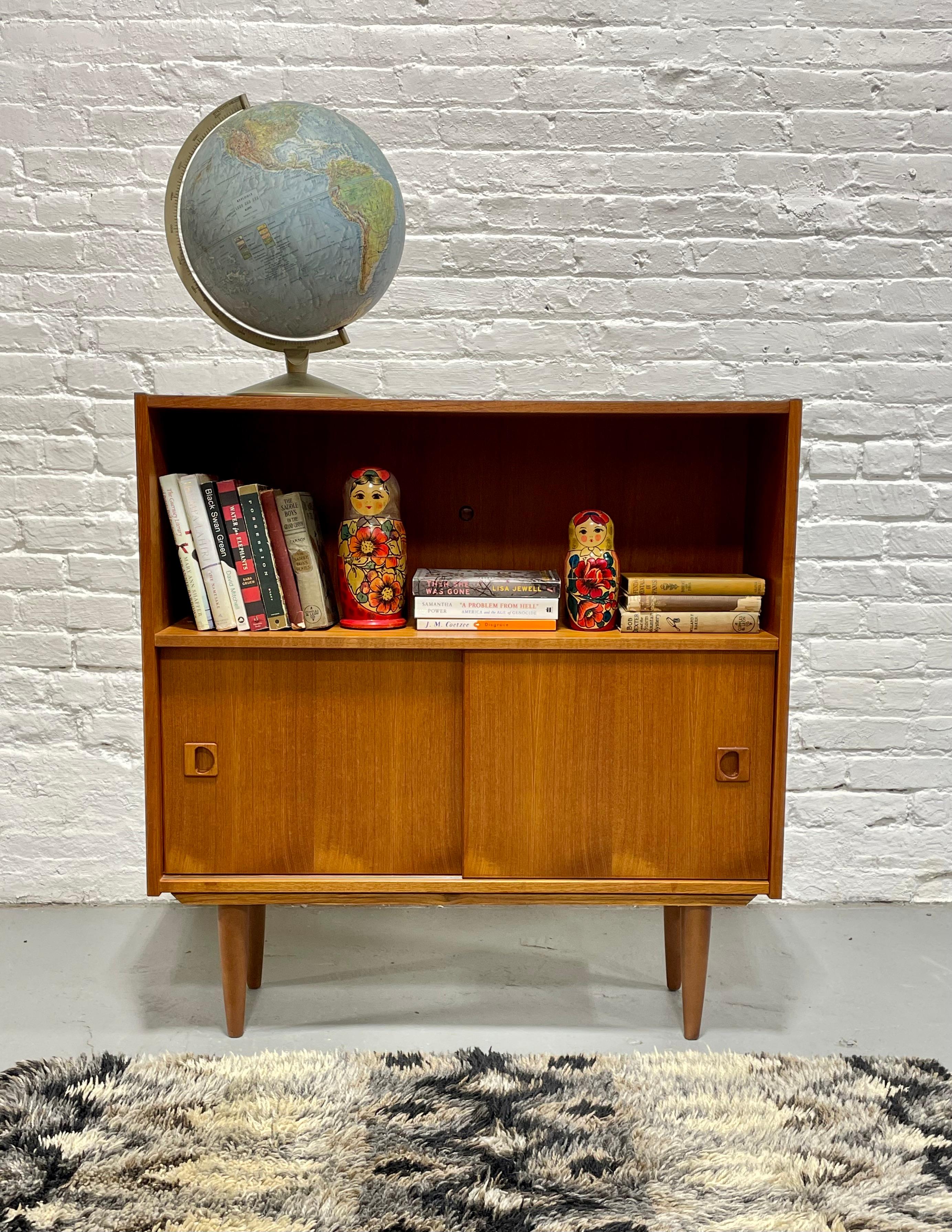 Danish Mid Century Modern Teak Bookcase, c. 1960’s.  Great combination of exposed storage in the upper area - perfect for books and collectables across the top shelf and an adjustable shelf in the lower area for additional storage.  This piece would