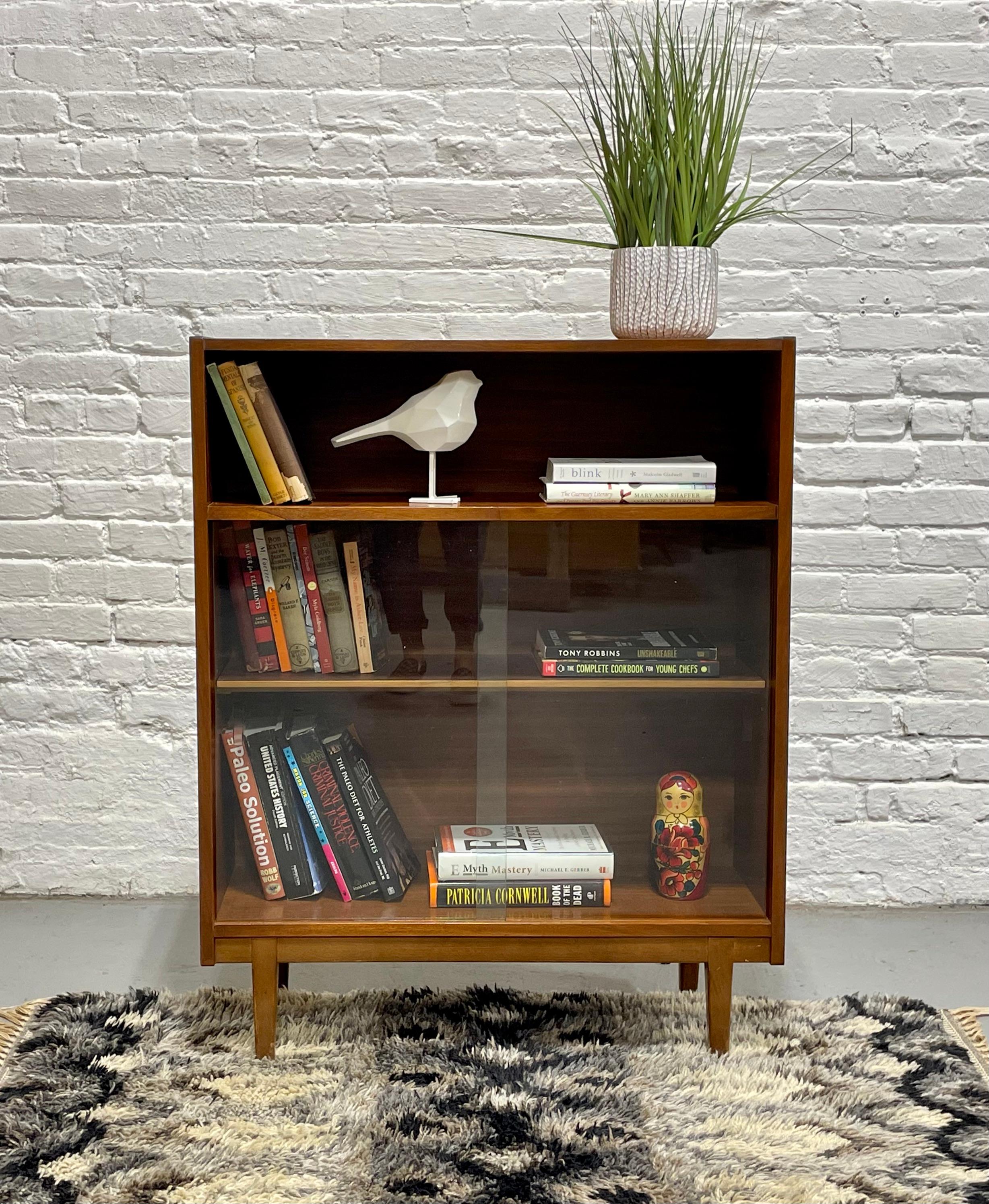 Apartment sized Teak Mid Century Modern BOOKCASE, c. 1960's. This super cute & solid piece has sliding glass doors along the lower area, perfect for keeping the dust out.  This apartment friendly size allows for a good deal of storage without taking