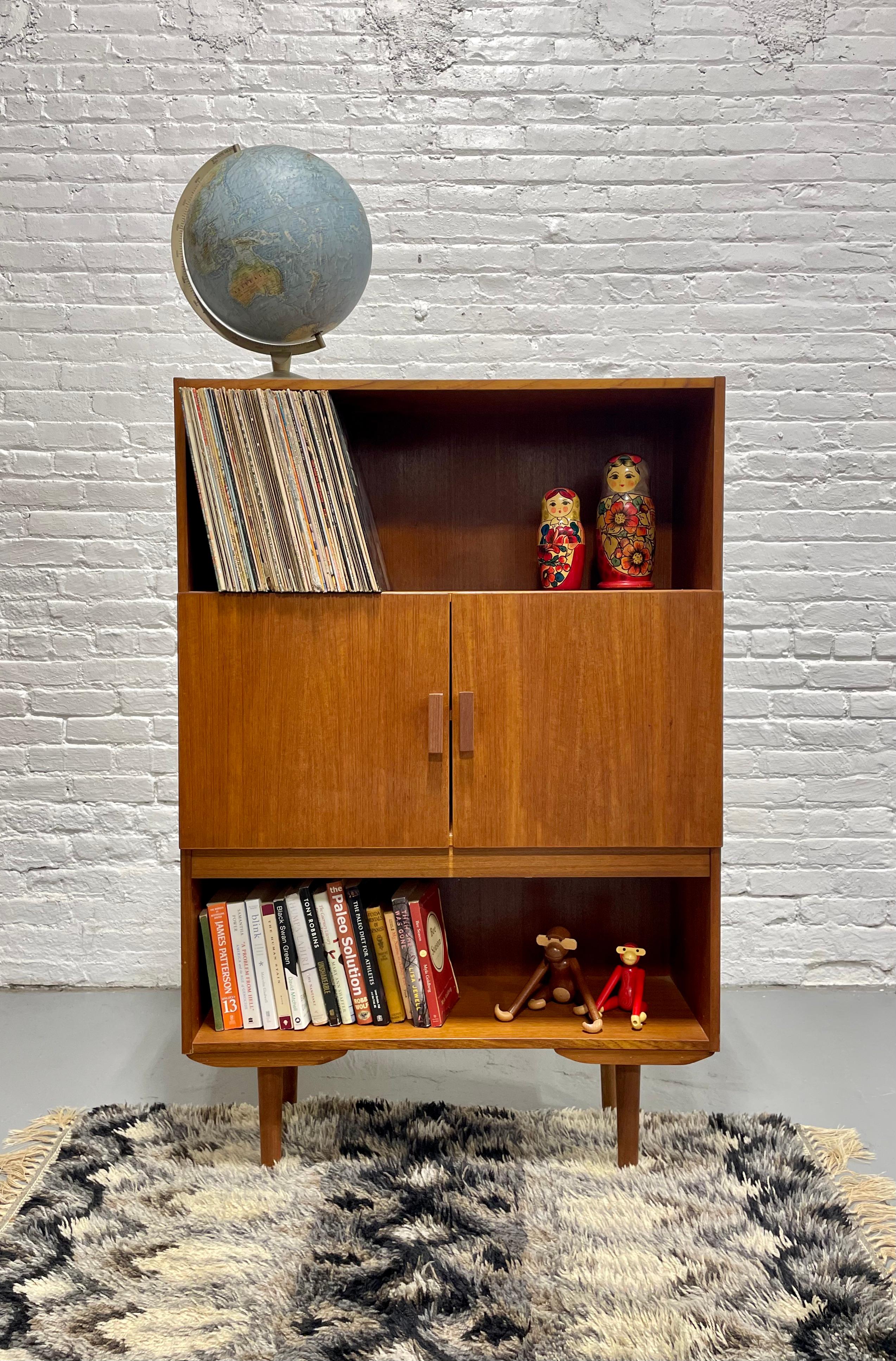 Danish Mid Century Modern Teak Bookcase / Liquor Bar Cabinet, c. 1960’s.  Loads of storage for all your books and collectables or vinyl collection across the top.   Plenty of storage options which allow some areas to be exposed and some hidden