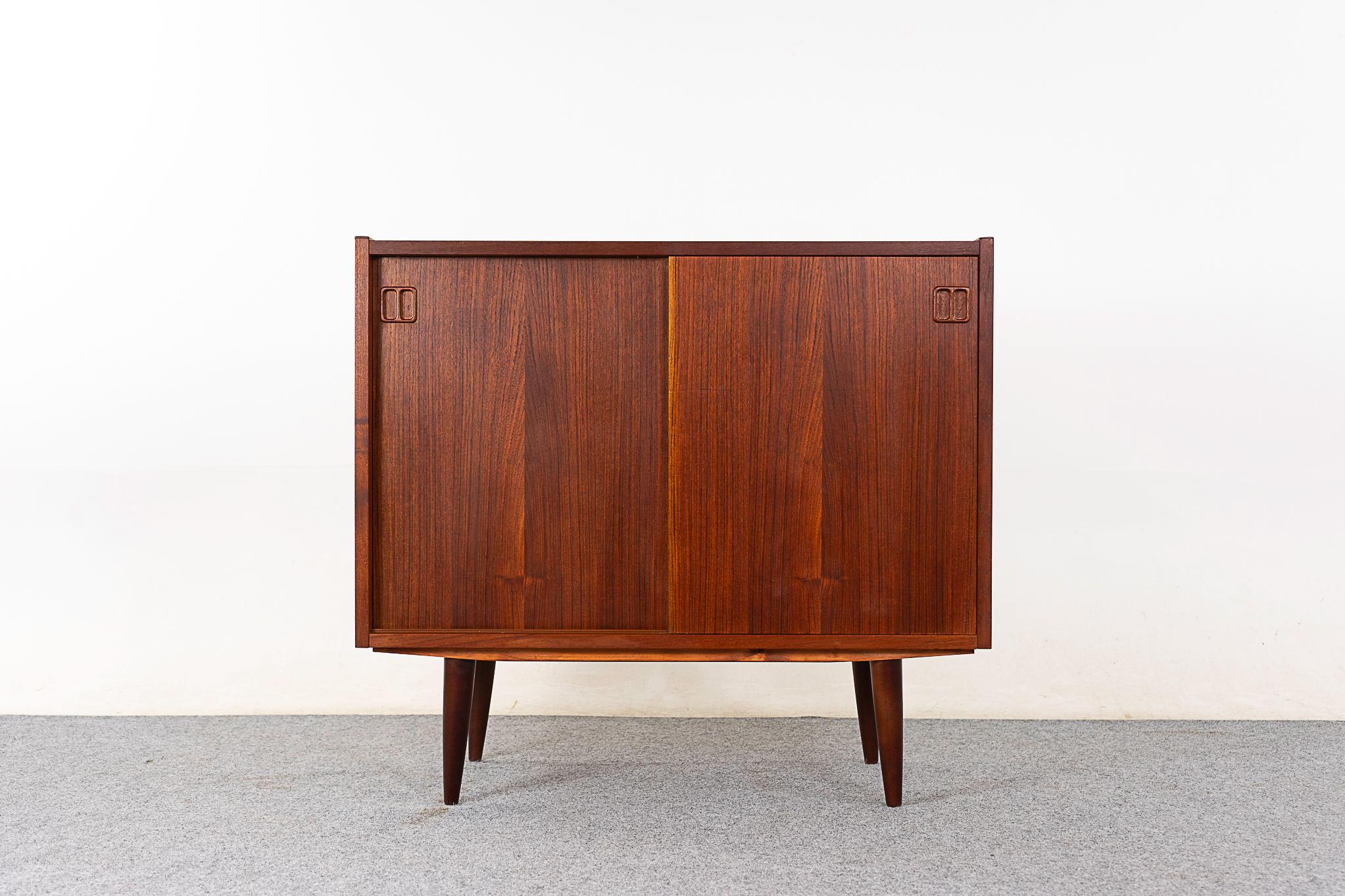 Teak Danish cabinet, circa 1960's. Clean, simple lined design highlights the exceptional book-matched veneer throughout. Height adjustable shelf. Minor veneer damage on side. 

Unrestored item with option to purchase in restored condition.
