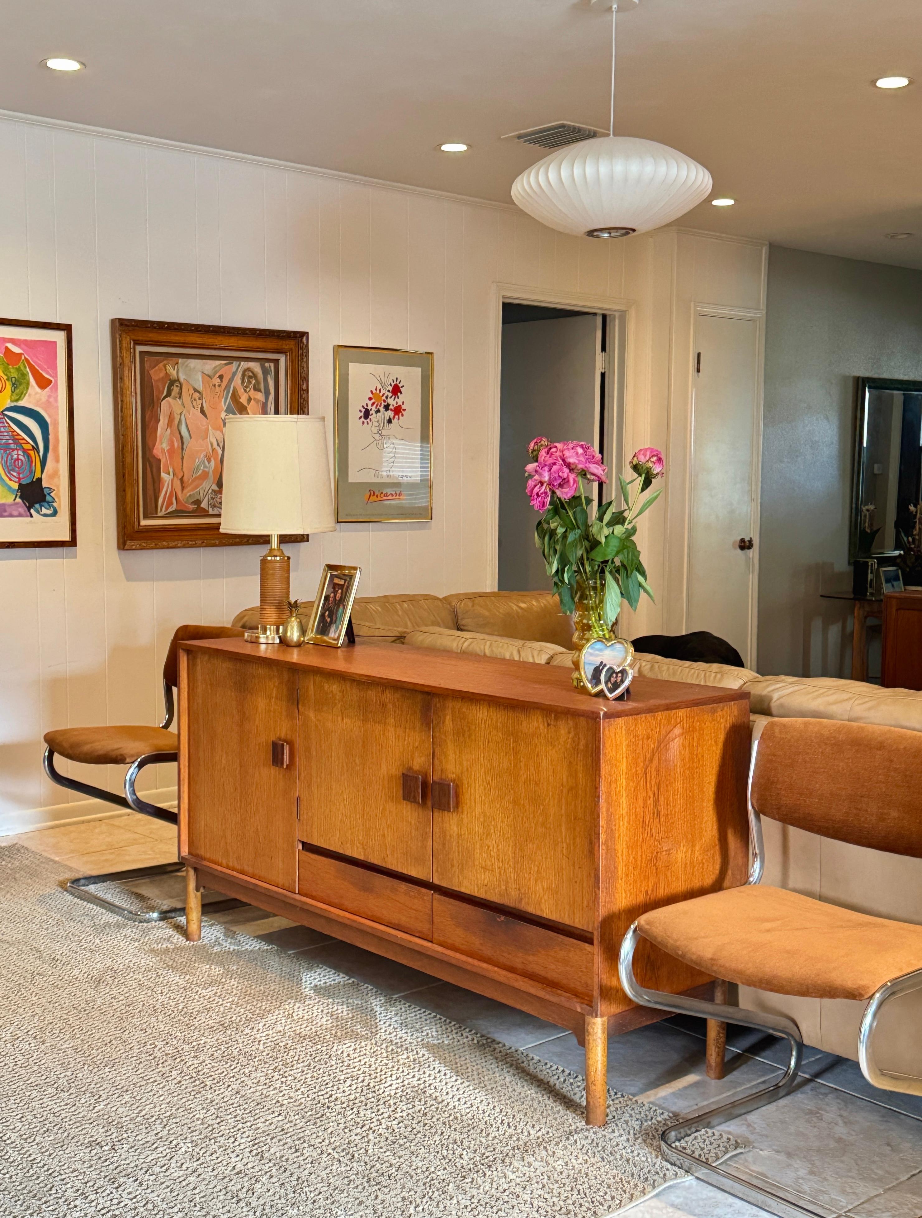 Danish mid century modern teak cocktail sideboard by Wrighton, circa 1960s. A beautifully crafted teak veneered sideboard with clean Scandinavian lines and a clever twist, literally. This piece features a rotating cylindrical bar cabinet on the left