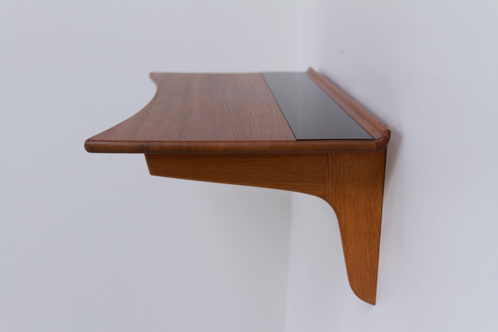 Danish Mid-Century Modern Floating Teak Console Table, 1950s.
Stylish Scandinavian Modern floating wall shelf with two drawers. Inward curved top with inlaid Formica strip. Back with raised edge trim. Supported on two solid oak brackets. Underneath