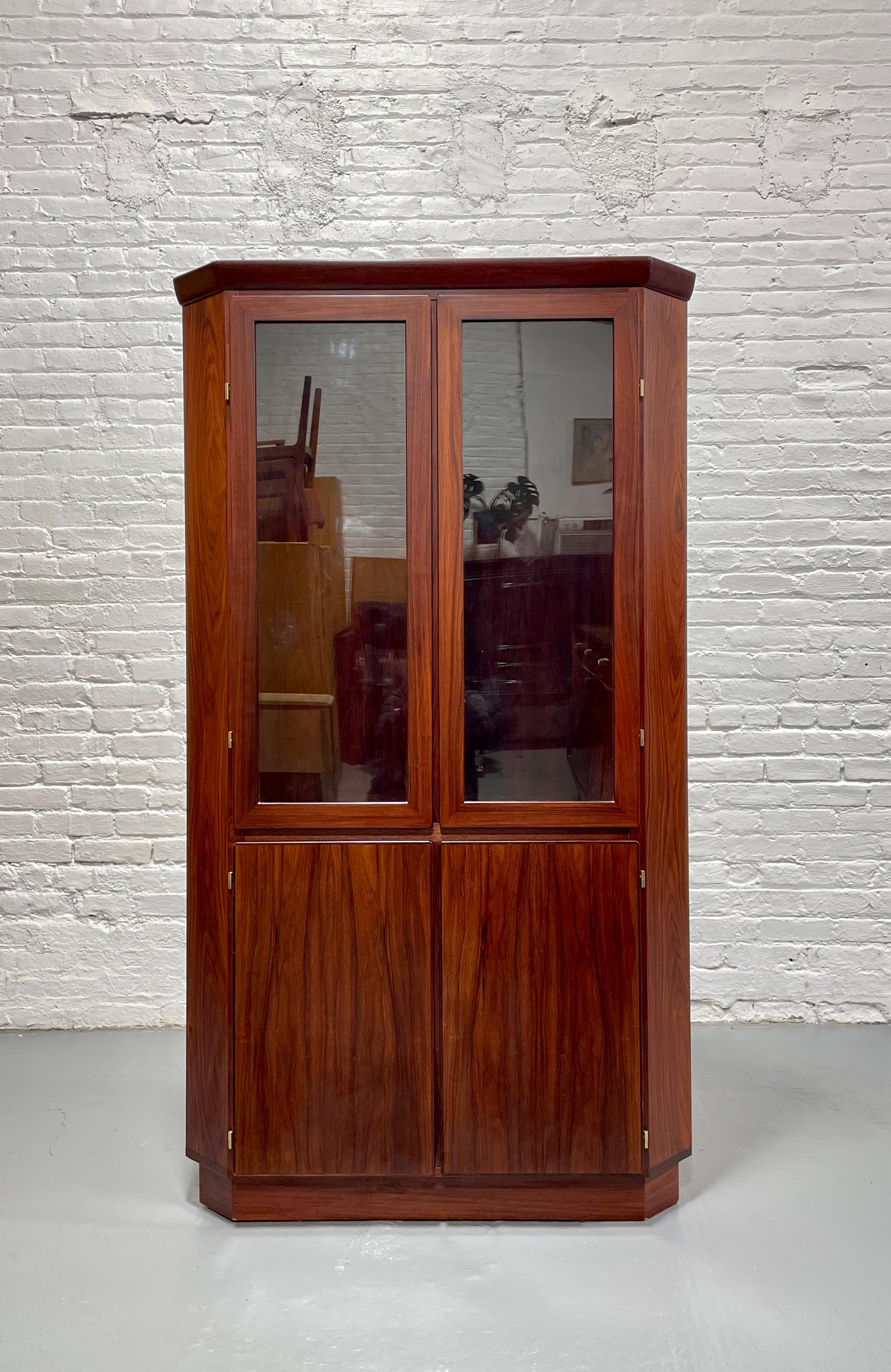Mid Century Modern Rosewood corner bookcase / china cabinet, Made in Denmark by Skovby. This piece boasts stunning wood grains, both inside and outside the cabinet and is perfect where space is an issue as it offers plenty of storage space yet fits