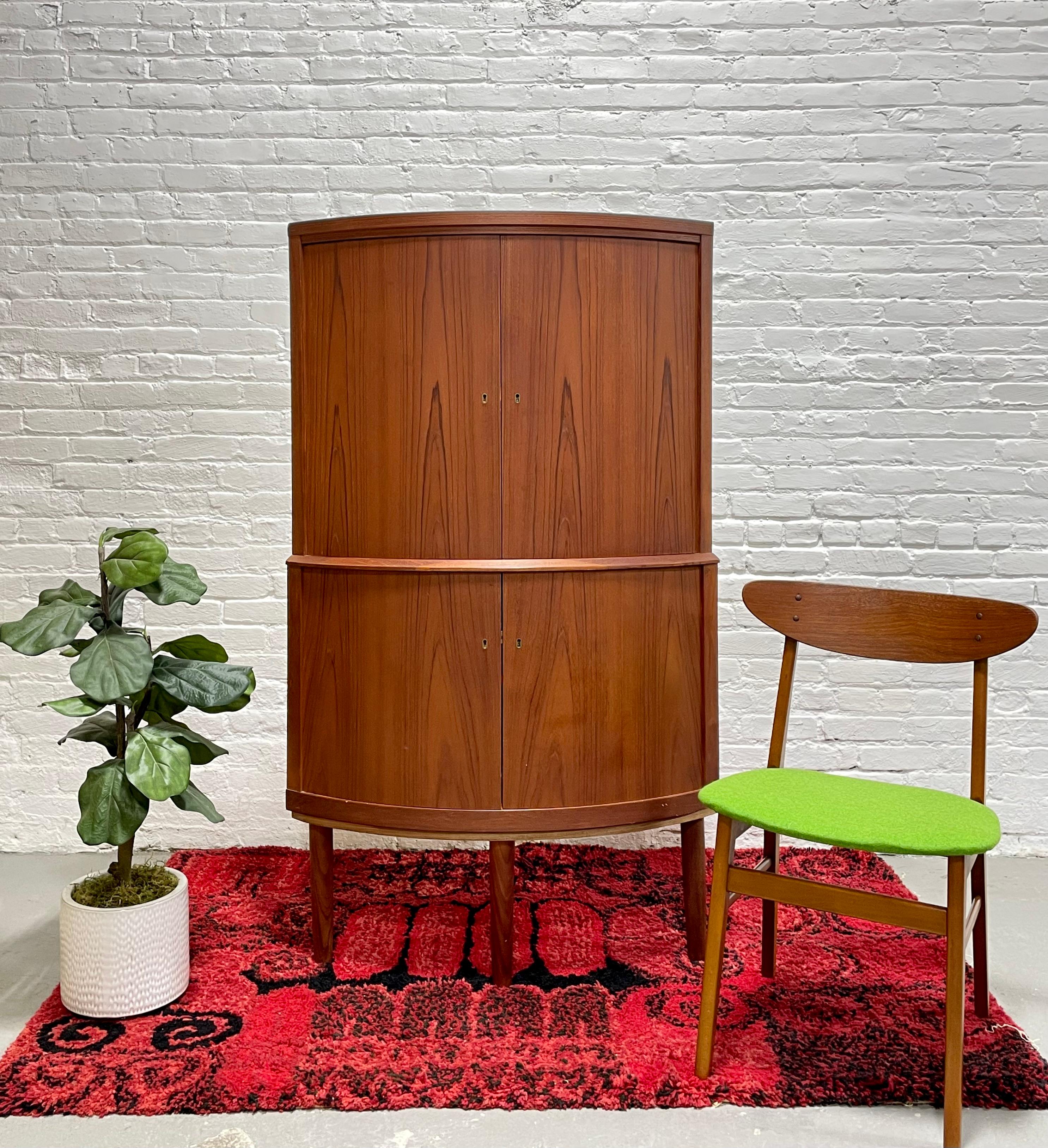 Mid Century Modern Teak Corner Liquor Bar / China Cabinet, Made in Denmark. Perfect piece where space is an issue as it offers plenty of storage space yet tucks away neatly into a corner taking up minimal floor space. Mirrored upper area - set up