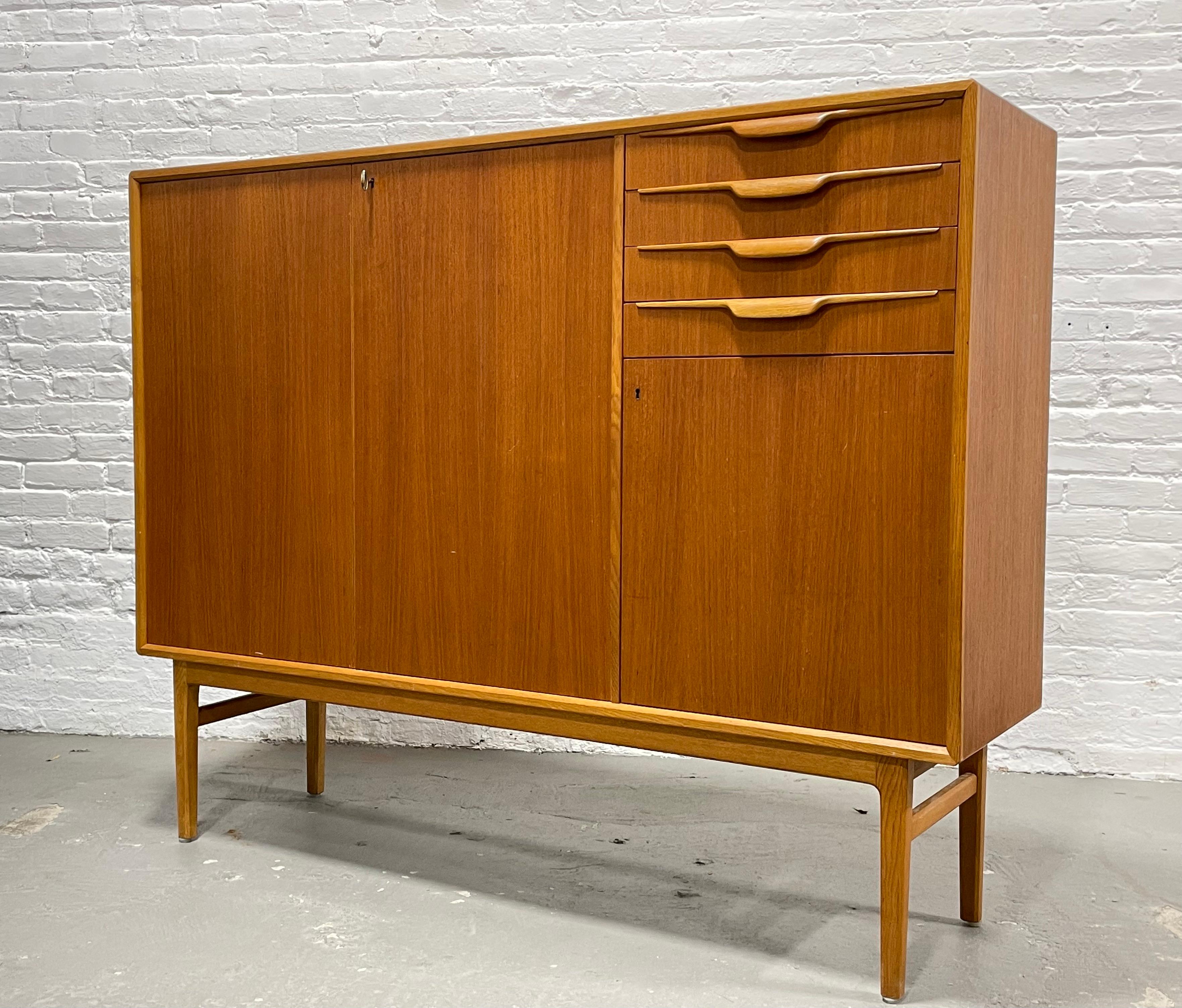 Mid-Century Modern Danish teak highboard credenza / sideboard by Beril Fridhagen for Bodafors, c. 1960's. This incredible piece is gorgeous in its simple yet extremely functional design. This beauty offers double lockable doors (key included!) with