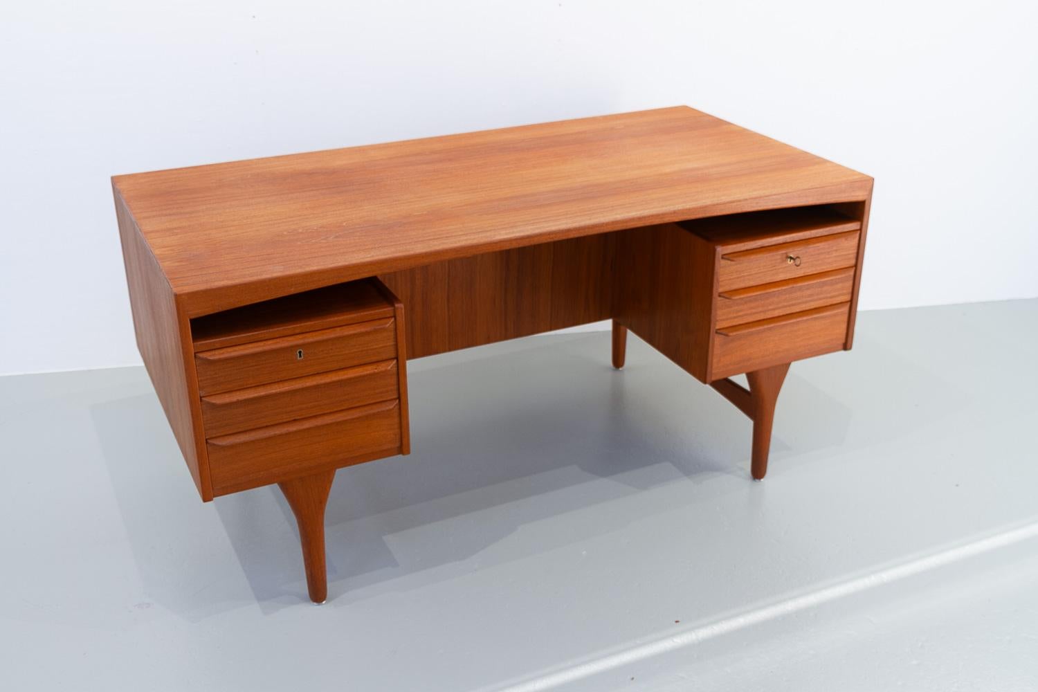 Danish Mid-Century Modern Teak desk by Valdemar Mortensen, 1960s.
High-end freestanding executive teak writing table by Danish master carpenter Valdemar Mortensen from Odense, Denmark.
Table top with arched trim and book matched veneer.
Front with
