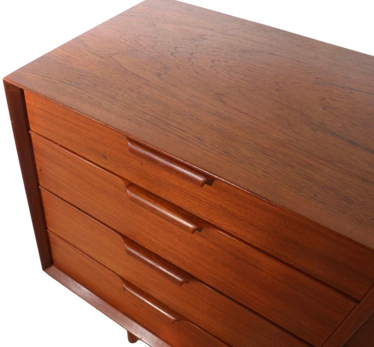 Architectural Danish Mid-Century Modern dresser by Falster Mobelfabrik.
This exceptional dresser features two banks of four drawers each flanking a tambour roll center panel that opens to five interior drawers.
This pieces is in very good original
