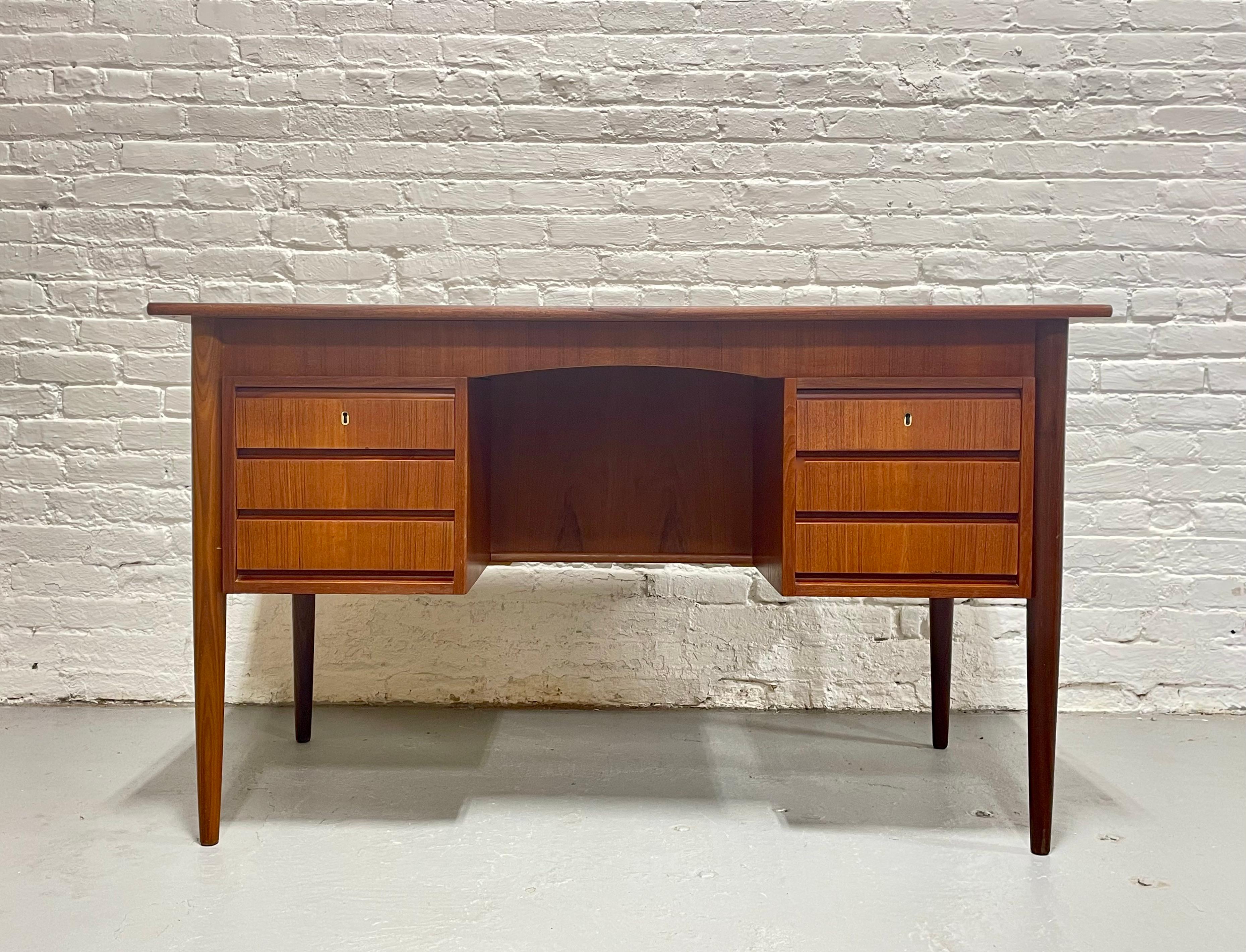 Absolutely Stunning Mid Century Modern Danish Teak Double Sided Desk, Made in Denmark, circa 1960s. This beauty offers three drawers along each side and an open area bookcase / display case at the back. Perfect piece if you need it to float in a