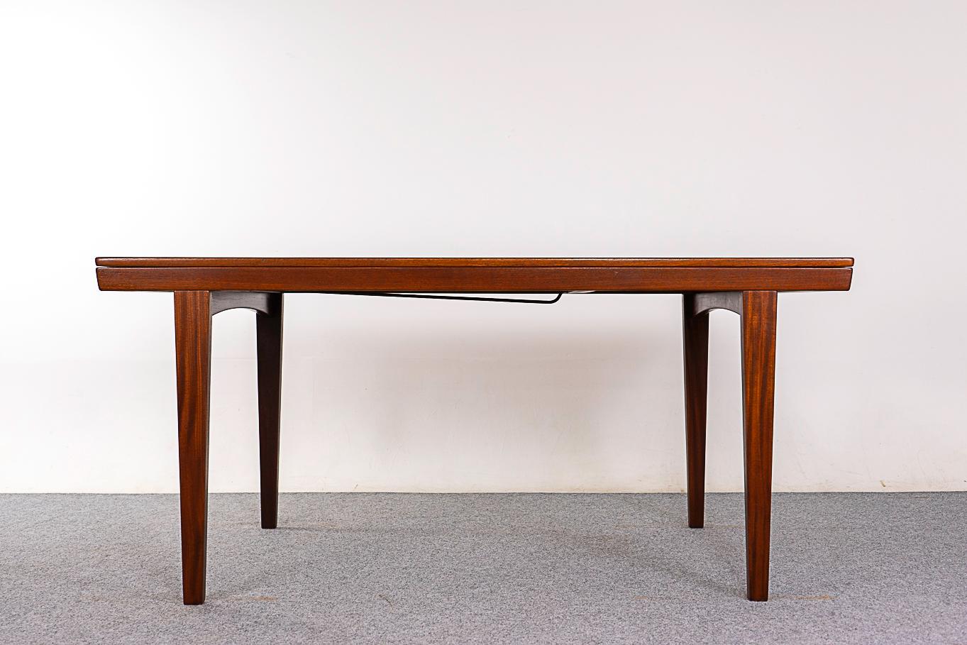 Teak Danish dining table, circa 1960's. Top is framed with solid wood trim, center panels feature highly figured book-matched grain veneer. Unique design, table top slides open to access the self storing leaf. Danish Furniture Makers' Control stamp