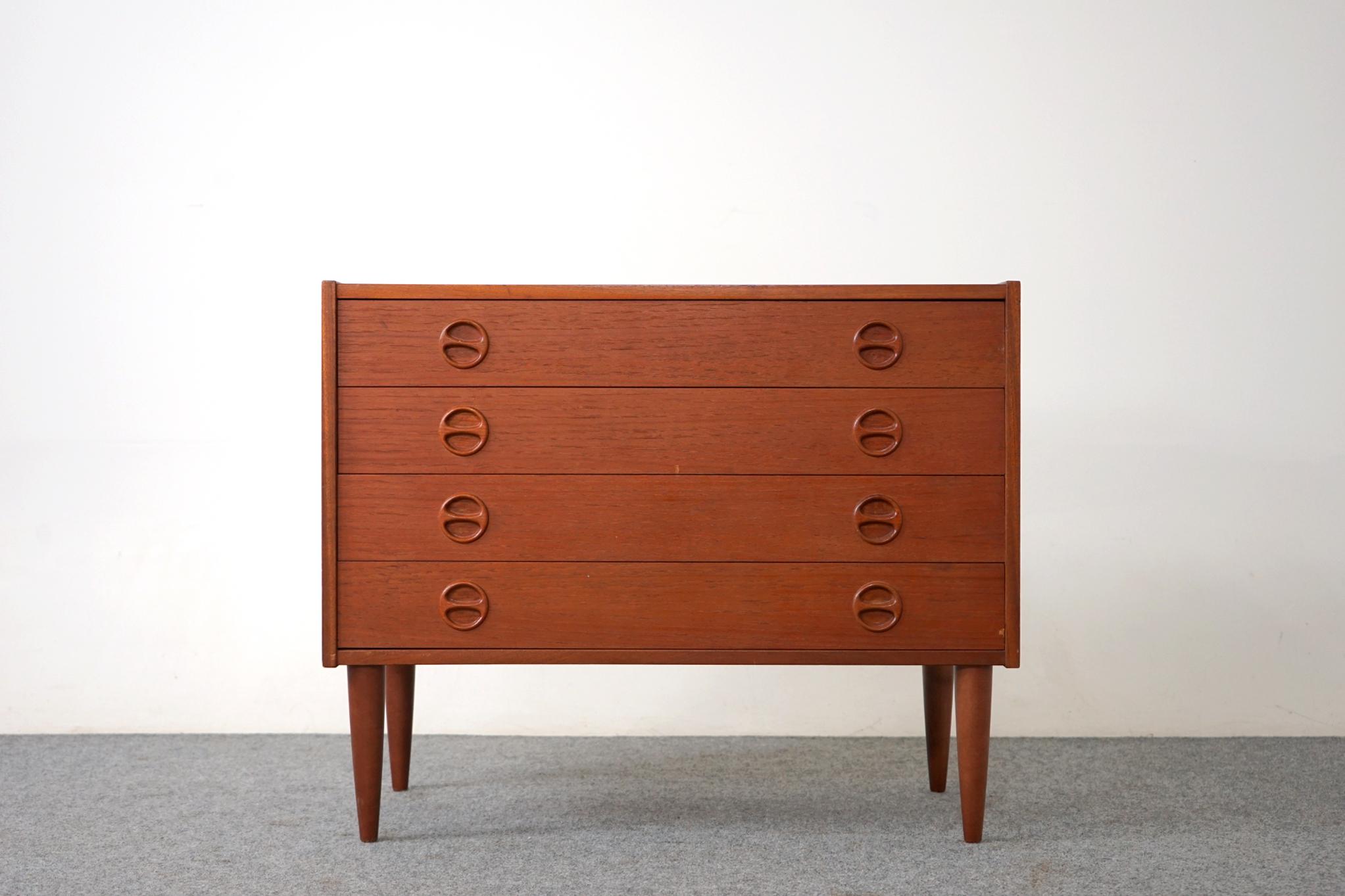 Teak Danish dresser circa, 1960's. Unique, solid wood circular pulls on each drawer provide a simple yet stylish handle to open the drawers. This four drawer dresser features solid wood edging with stunning book-matched veneer on all drawer faces