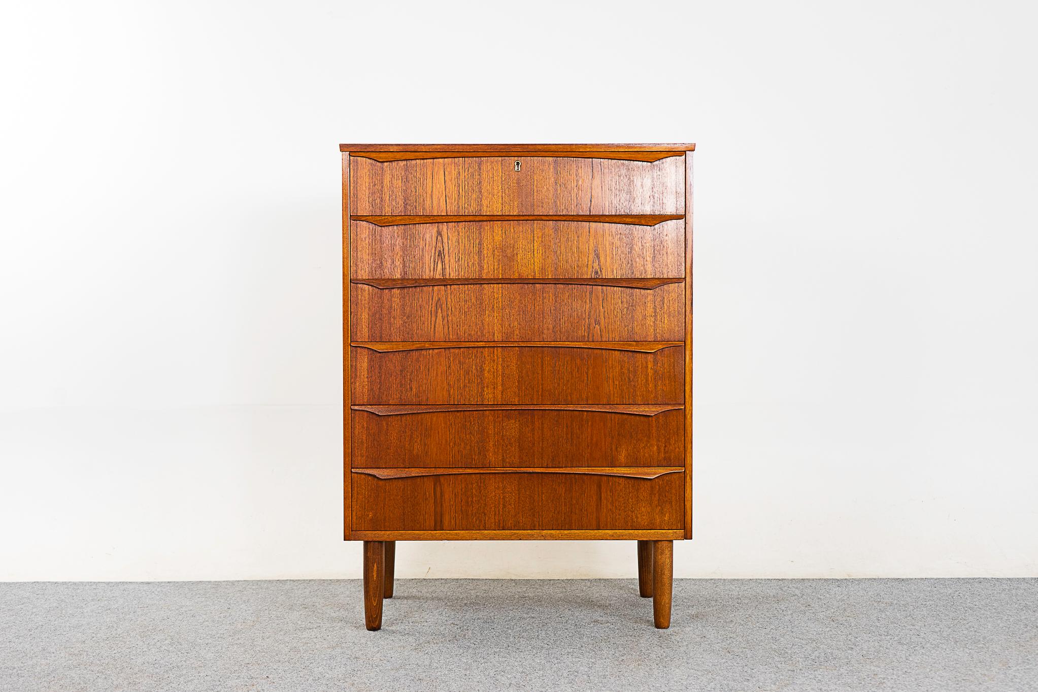 Teak Danish highboy dresser, circa 1960's. Solid wood edging with stunning book-matched veneer on all drawer faces. Integrated, horizontal drawer pulls and dovetail construction! Tapering solid oak legs.

Please inquire for international and remote