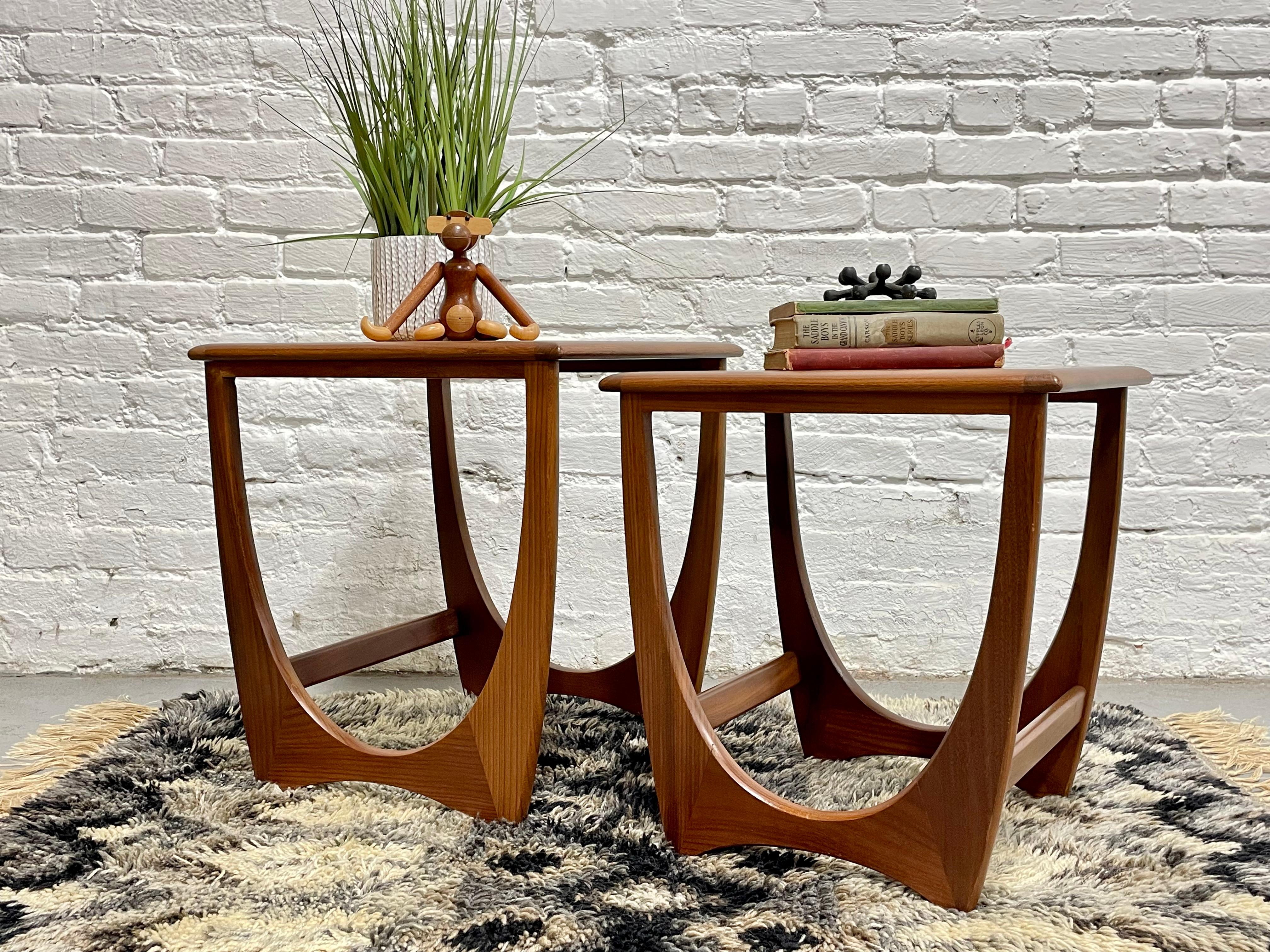 Mid Century Modern Teak Danish Nesting Tables / Side Tables by Victor Wilkins for G- Plan, c. 1960's.  The frames are teak with afromosia trim and gorgeous wood grains along the frame and tabletop. The smaller table tucks under the larger one so you