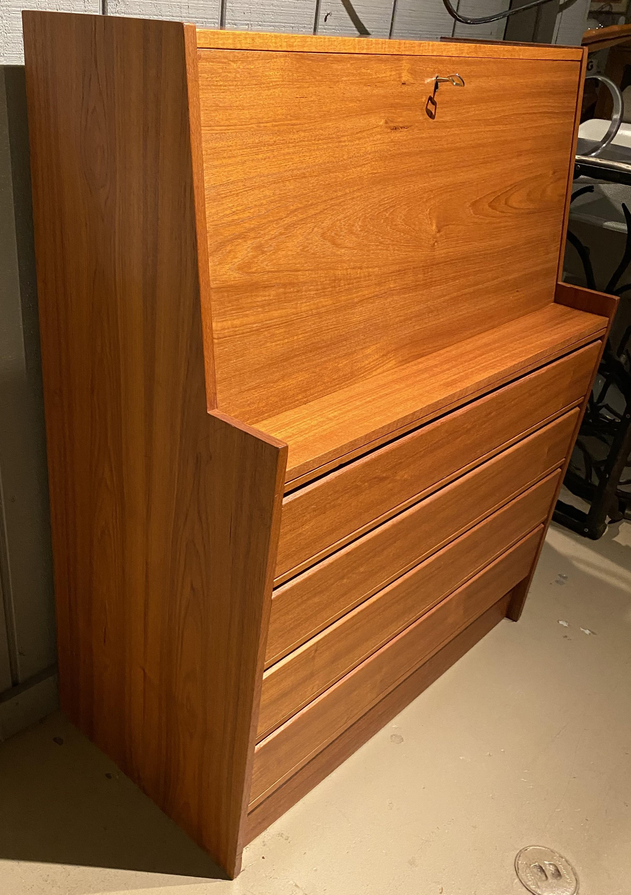A great size and form Danish Mid Century Modern fall front desk in teak with compartmentalized interior with three fitted drawers and open shelves, over four long drawers below the writing surface. Stamped on base “Made in Denmark”. Great for any