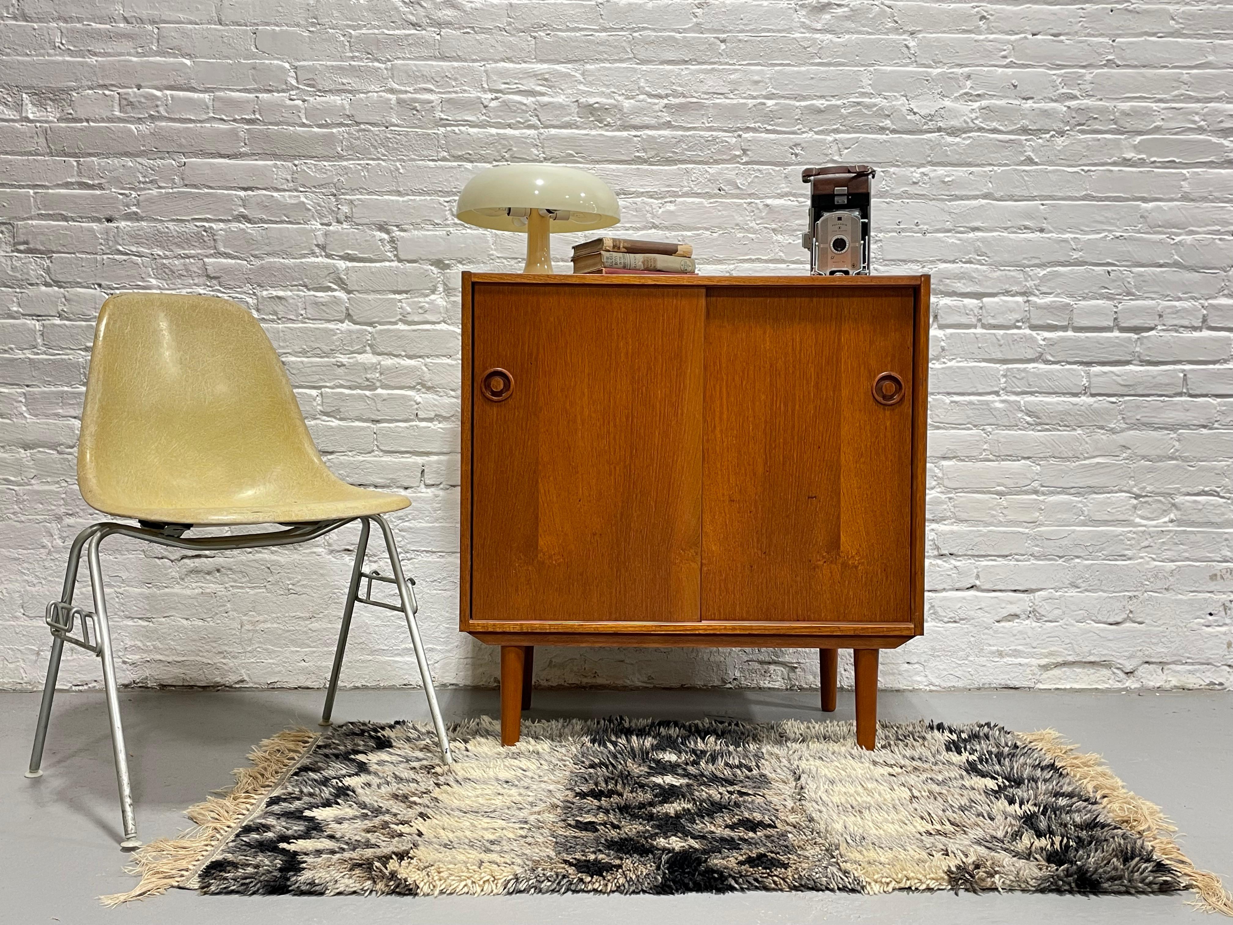 Mid Century Modern Teak Jr. Credenza / Storage Cabinet, c. 1960's.  While small and streamlined, this cabinet offers a vast amount of storage space, enough for several components above and below the shelf if used as a media stand or alternatively, a