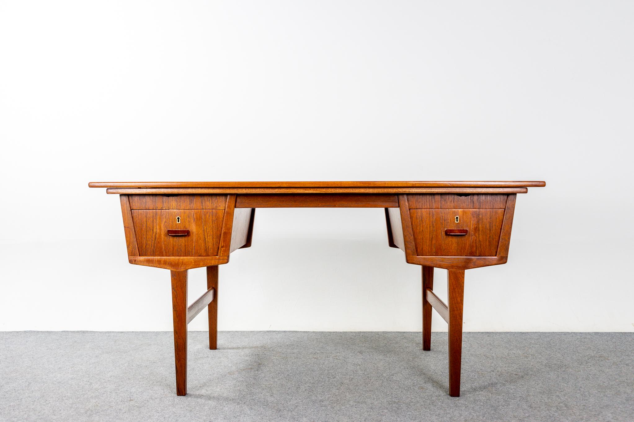 Teak Danish partner desk, circa 1960's. Double trouble. Metamorphic partner desk has two draw leaves that expand to create a large work area. Unique design has duals workstations, allowing users to face each other. Front and back of desk are