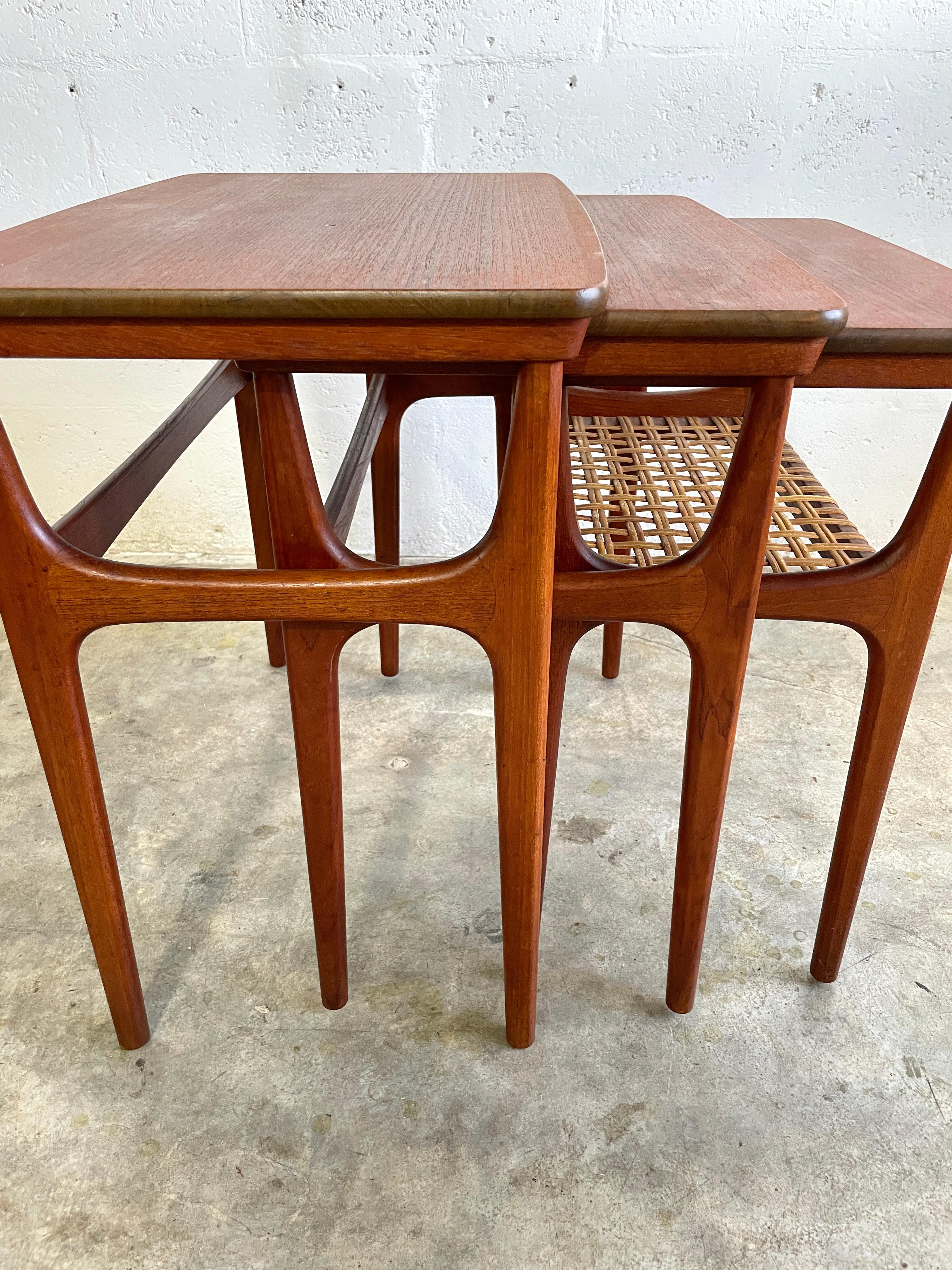 Danish Modern Teak Nesting Tables by Erling Torvits for Heltborg Møbler Denmark 1950s. Model No. 15. Frames in solid teak with tapered rounded legs. Smallest table has a shelf with original woven cane. 22w 21h 13.5d