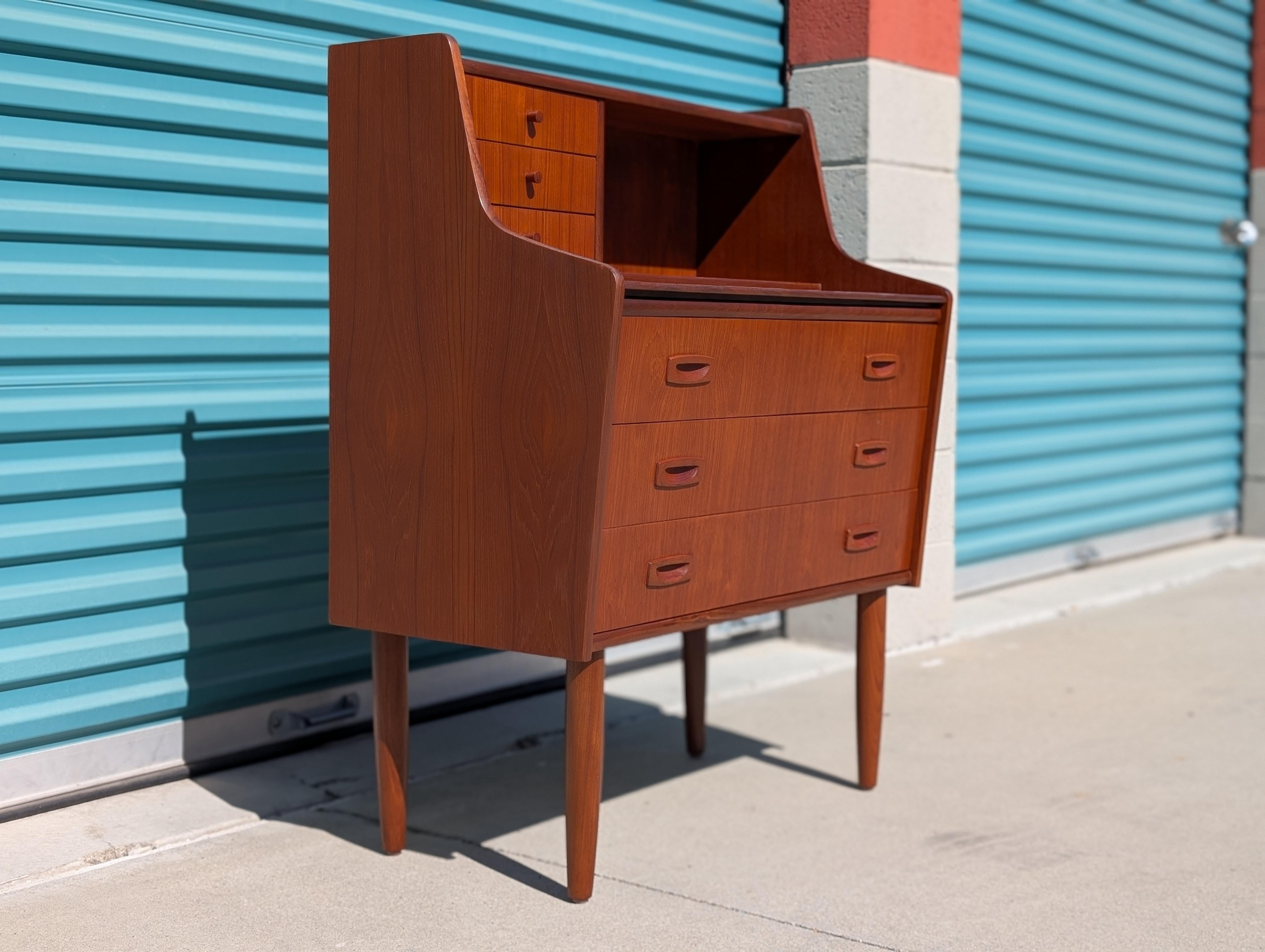 Ce bureau secrétaire danois en teck du milieu du siècle, vers les années 1960, incarne le savoir-faire raffiné et l'élégante simplicité qui définissent le design scandinave. Magnifiquement restaurée et en excellent état, cette pièce met en valeur