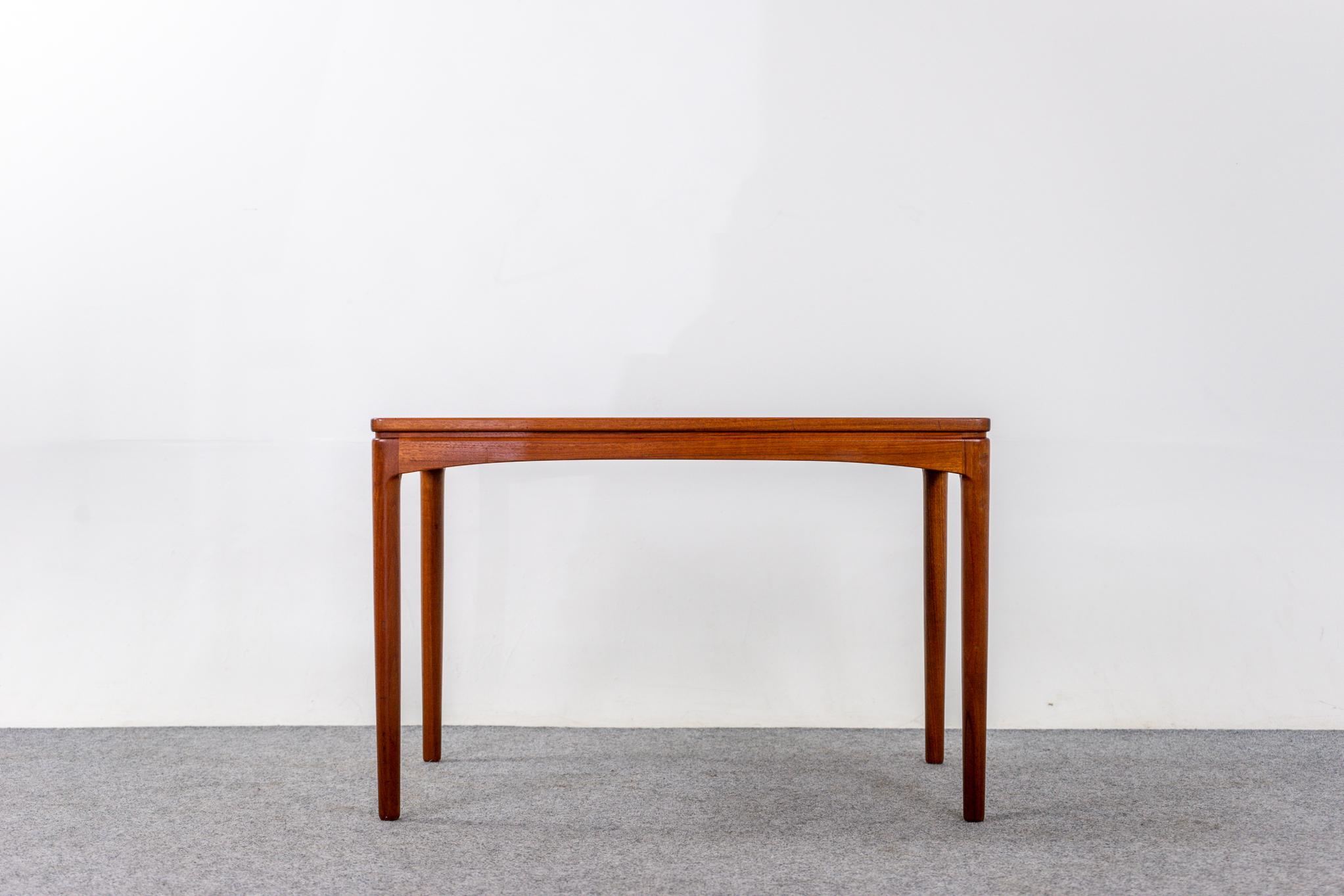 Table d'appoint danoise en teck, vers les années 1960. La base est en bois massif et les surfaces planes sont recouvertes d'un beau placage assorti au livre. Compacte et très fonctionnelle, cette table s'adapte parfaitement aux causeuses ou à tout