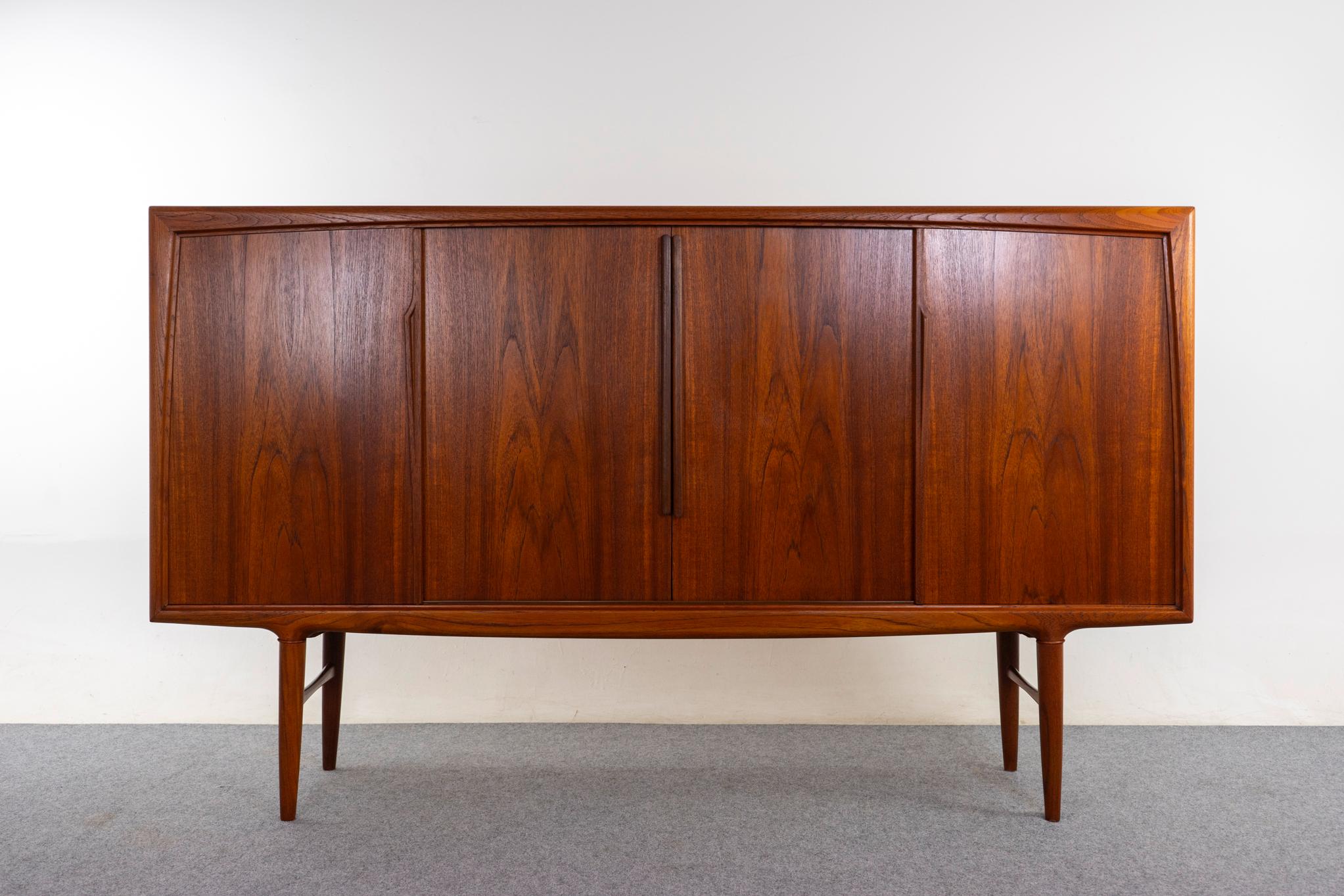 Teak Danish sideboard, circa 1960s. Sleek design with exceptional book-matched veneer throughout. Adjustable shelving x 4 and sleek flatware drawers with lovely joinery. Robust, sculptural base. Centre handles are aftermarket. 
