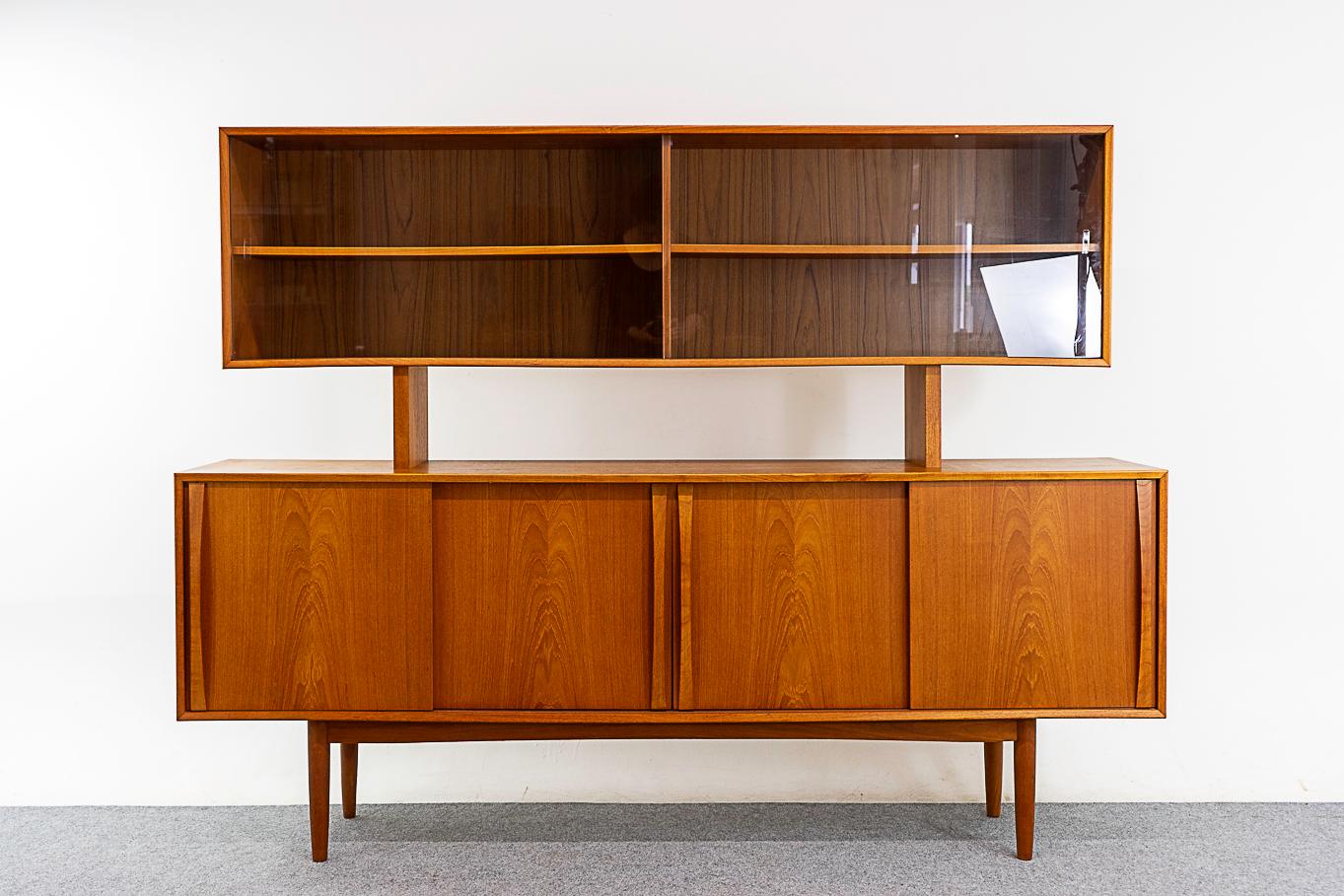 Teak Danish sideboard & hutch, circa 1960's. Beautiful bookmatched veneer, solid wood edging, elegant handles and sleek tapered legs. Spacious interior with height adjustable shelving and slender dove tailed felt lined drawers with solid teak
